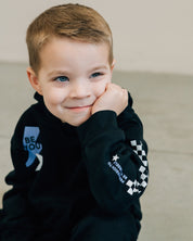 Child black sweater and joggers with checkers pattern on arm and leg, and blue lightning bolt with 'be you' in it flanked by a white star, seen on model - Little Mama Shirt Shop