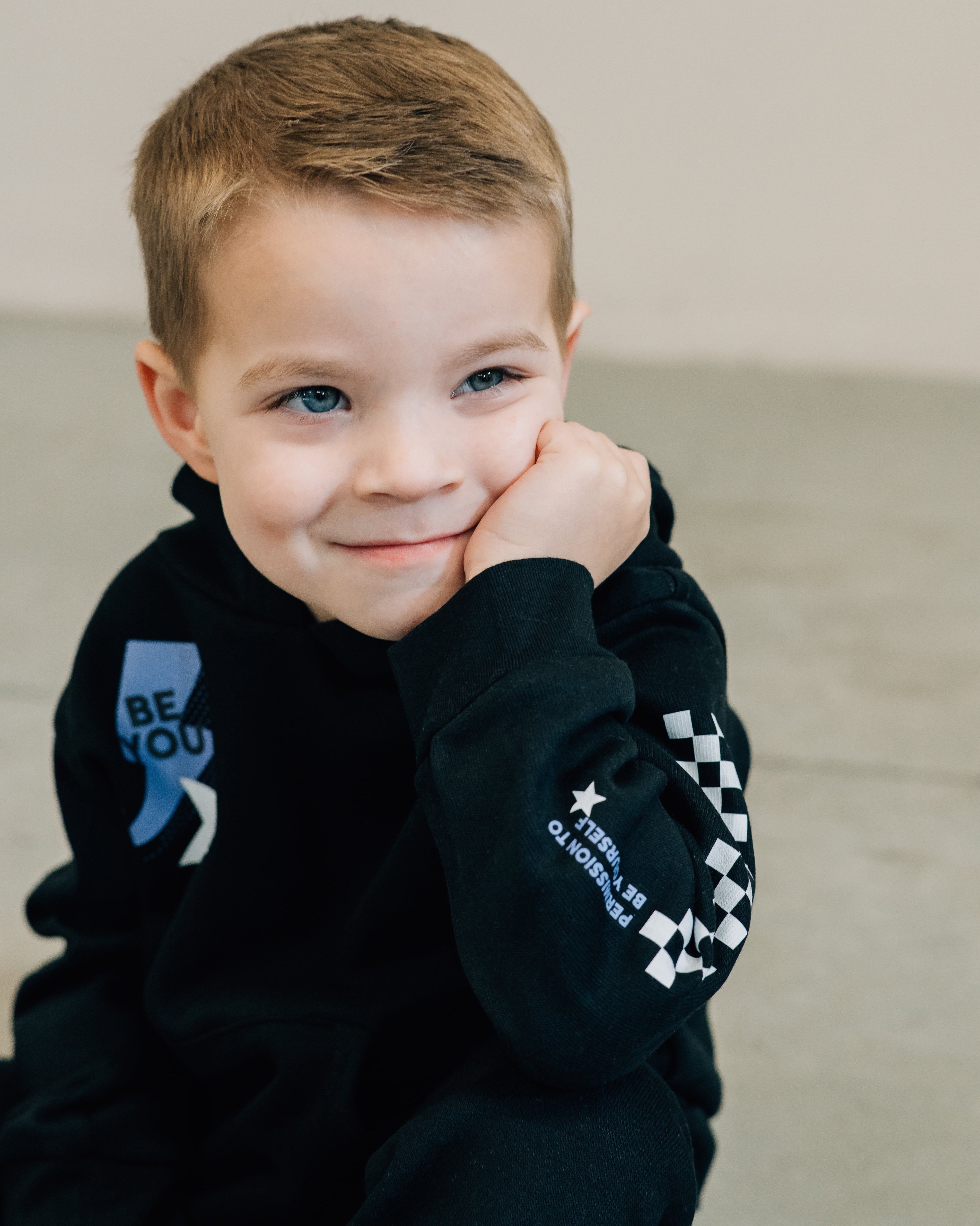 Child black sweater and joggers with checkers pattern on arm and leg, and blue lightning bolt with 'be you' in it flanked by a white star, seen on model - Little Mama Shirt Shop