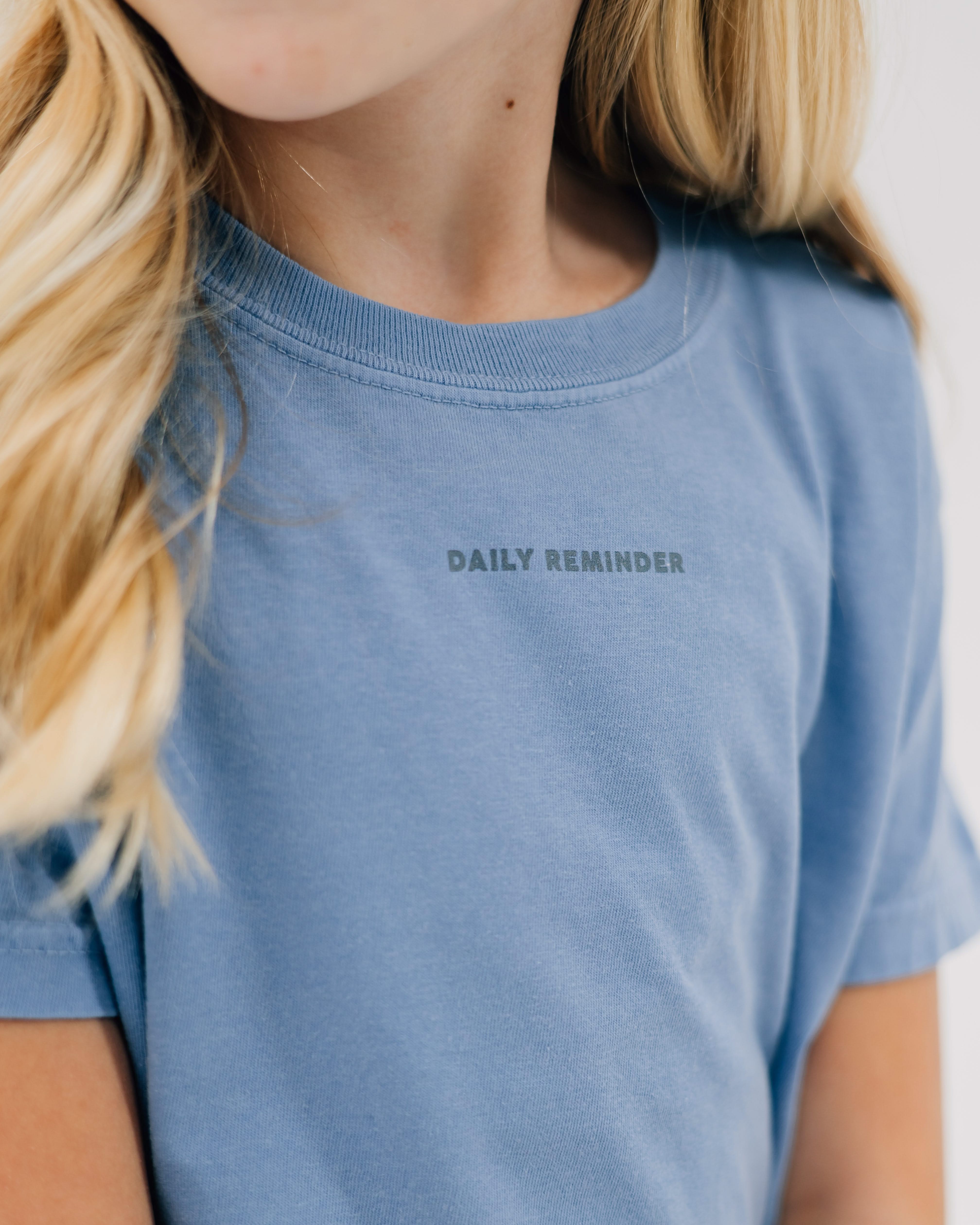 Washed denim comfort colors tee with 'daily reminder' printed on front, seen on model - Little Mama Shirt Shop