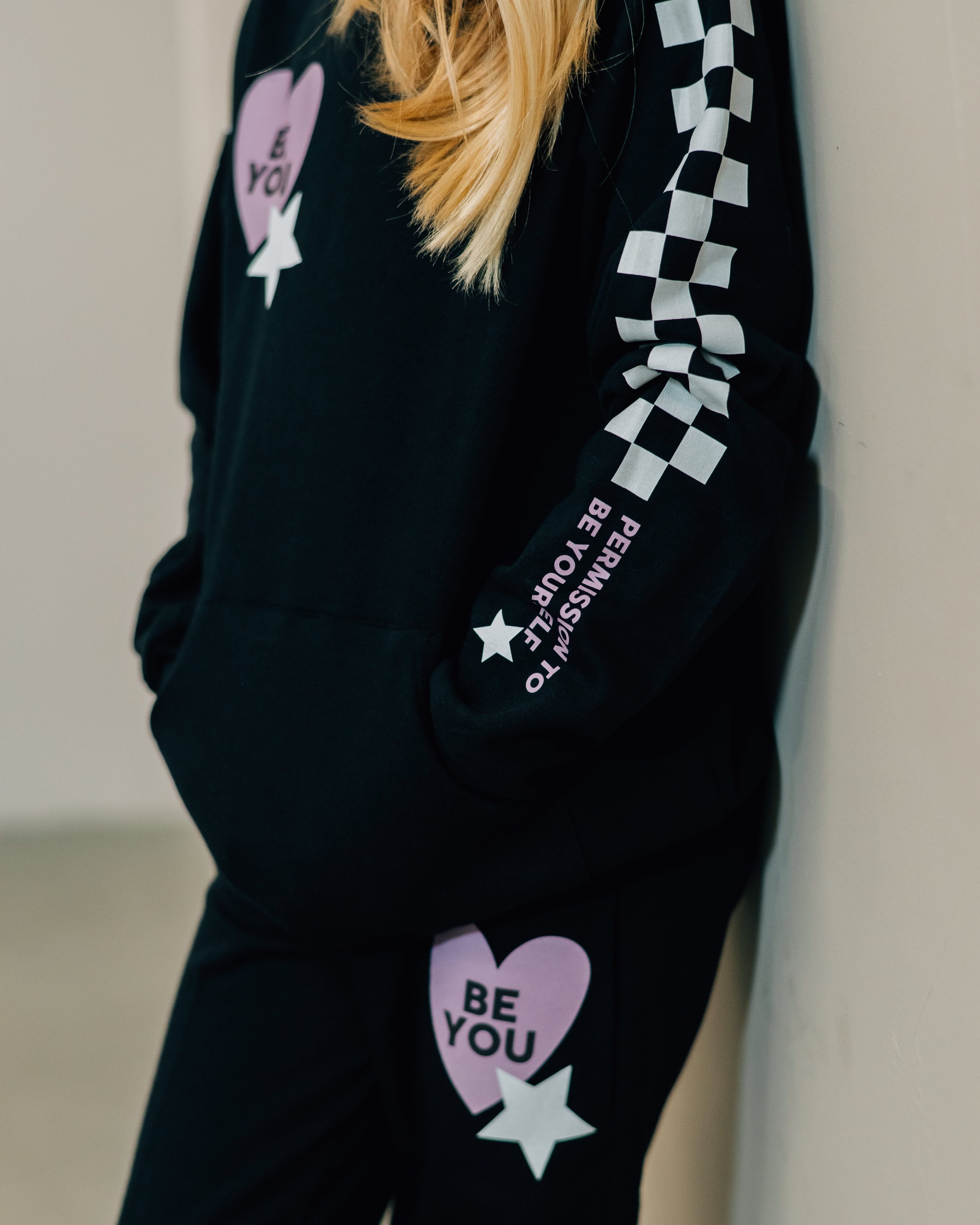 Child black sweater and joggers with checkers pattern on arm and leg, and Purple Heart with 'be you' in it flanked by a white star, seen on model - Little Mama Shirt Shop