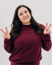 Maroon crewneck with "Permission To Be Optimistic" on chest, shown on model - Little Mama Shirt Shop
