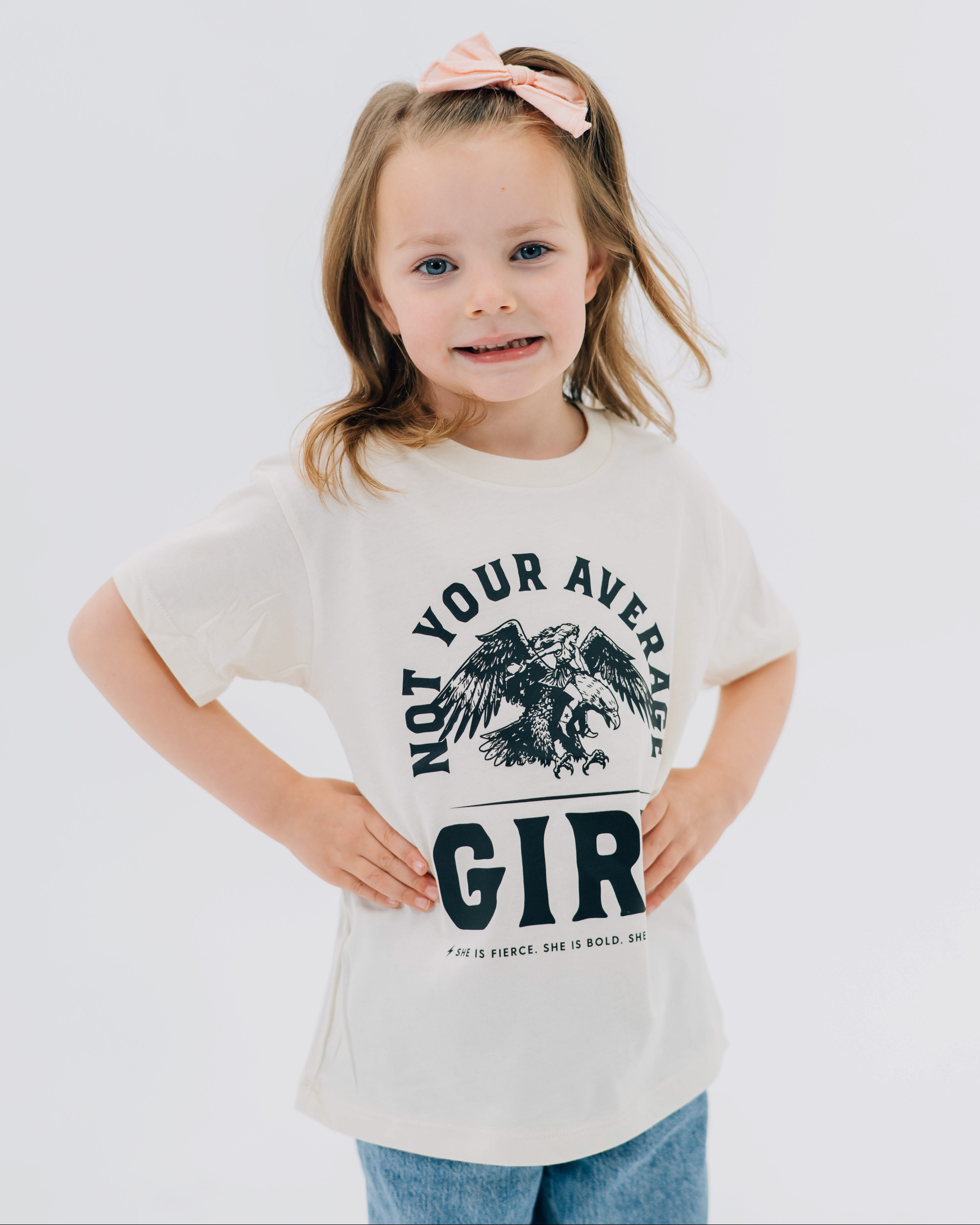 Child tee in natural with "Not Your Average" design on front, shown on model  – Little Mama Shirt Shop