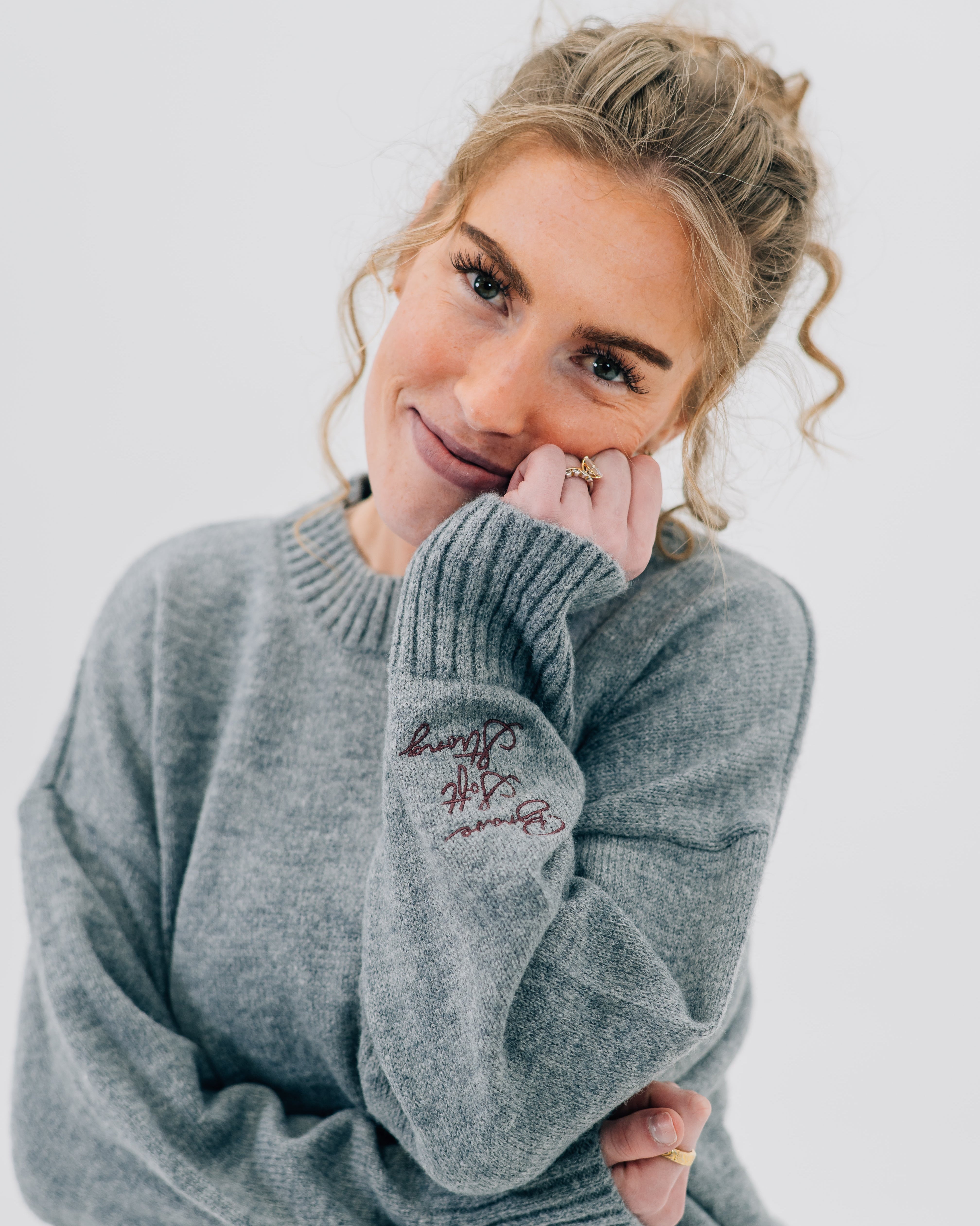 Gray sweater with "Brave, Soft, Strong" embroidered on the sleeve, seen on model - Little Mama Shirt Shop