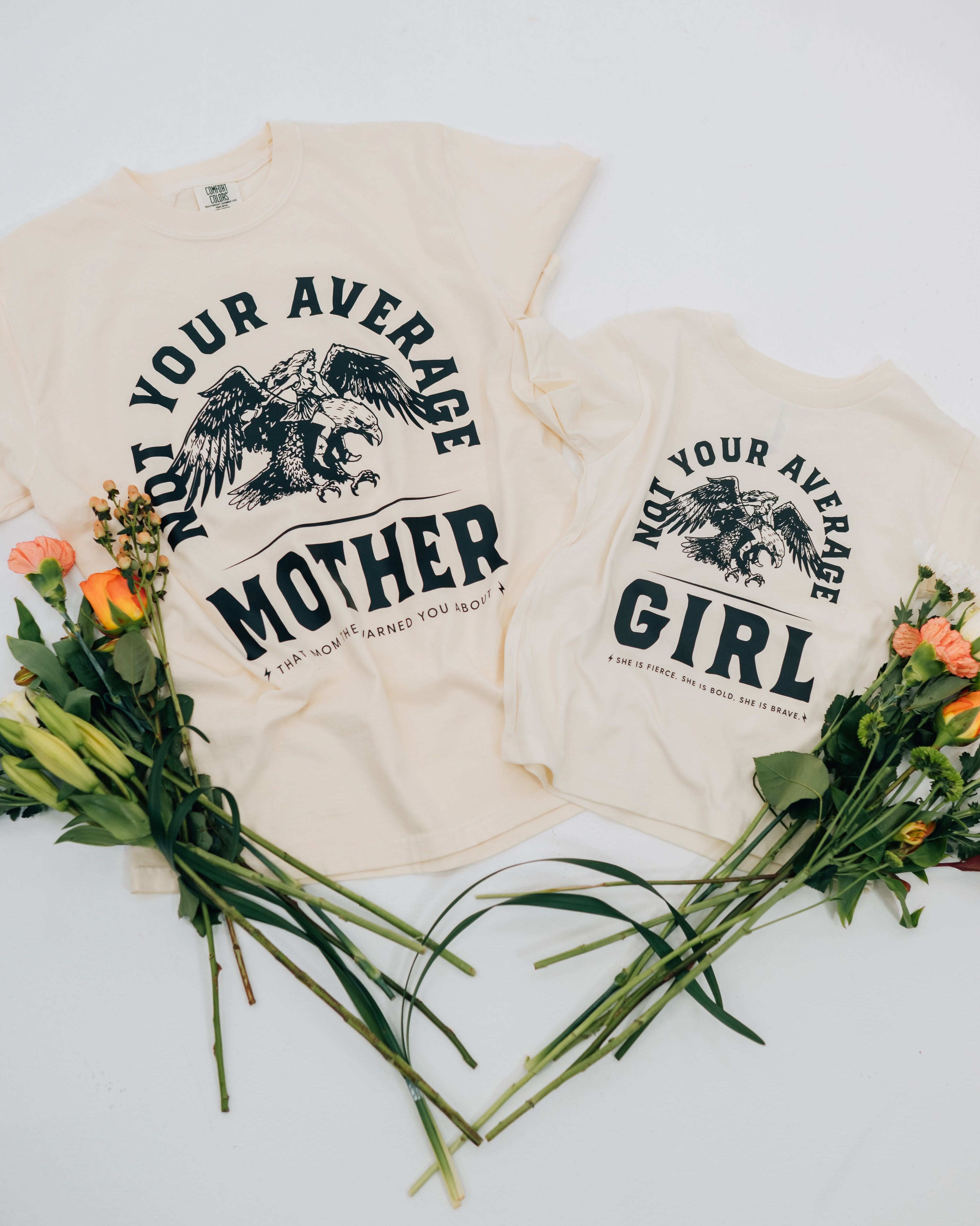 Adult and child tee in ivory and natural with "Not Your Average" design on front, shown on flat lay – Little Mama Shirt Shop