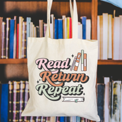 Beige canvas tote bag featuring a 'Read Return Repeat' design on a flat lay - Little Mama Shirt Shop