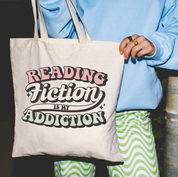 Beige canvas tote bag featuring a 'Reading Fiction is my Addiction' design on a model - Little Mama Shirt Shop
