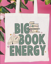 Beige canvas tote bag featuring a 'Big Book Energy' design on a flat lay - Little Mama Shirt Shop