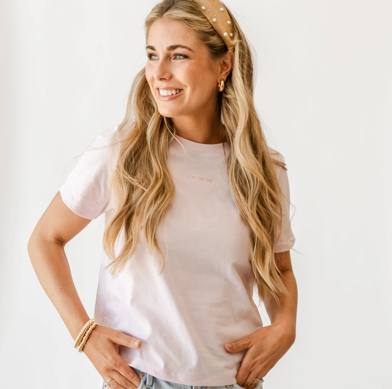 Adult tee in soft pink with mini symbol three bows design on front, shown on model – Little Mama Shirt Shop