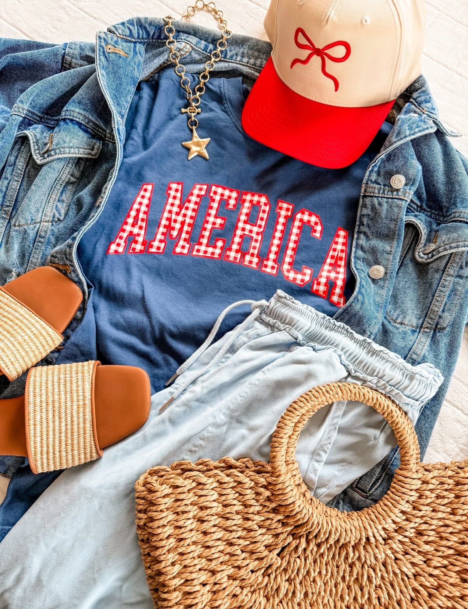 AMERICA shirts styled with a hat and woven bag, creating an easy red, white, and blue outfit idea