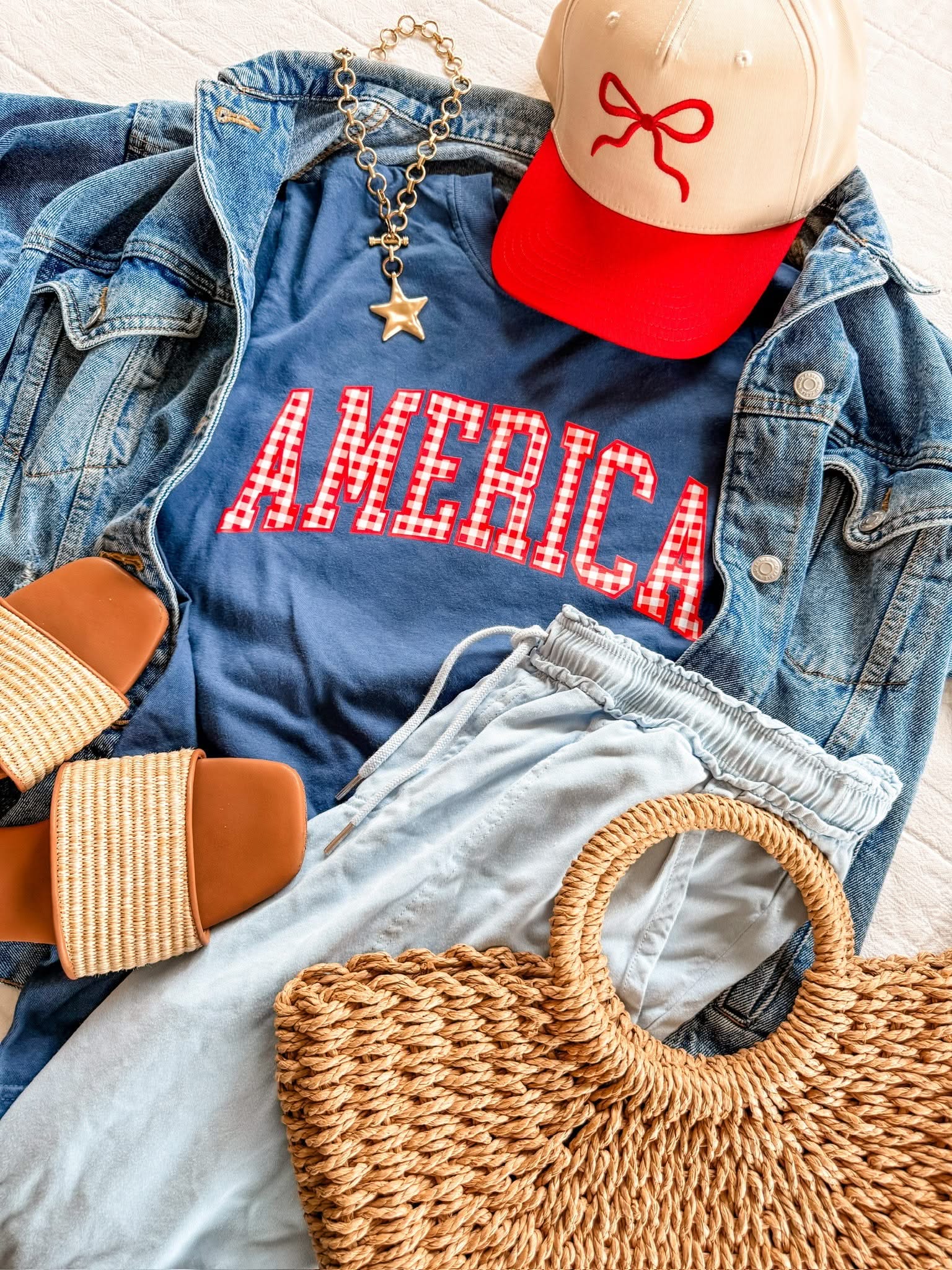 AMERICA shirts styled with a hat and woven bag, creating an easy red, white, and blue outfit idea