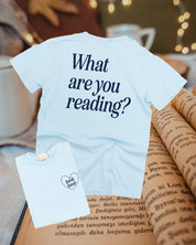 Youth comfort colors tee in chambray w/ navy detail with a 'book lover' heart graphic on the front and 'What are you reading?' graphic on back, shown on flat lay – Little Mama Shirt Shop