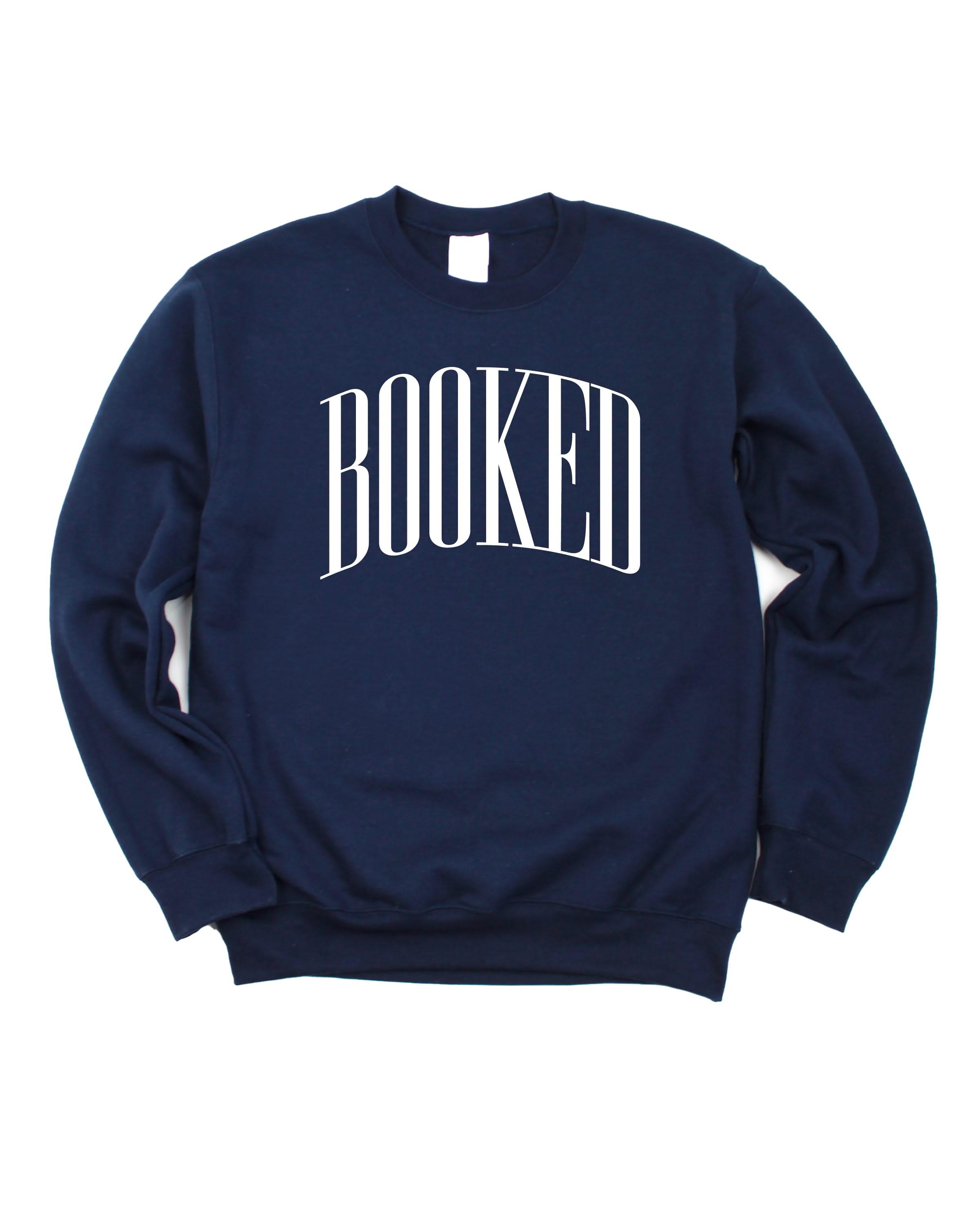 Basic fleece in navy with 'BOOKED' graphic on chest, shown on flat lay – Little Mama Shirt Shop