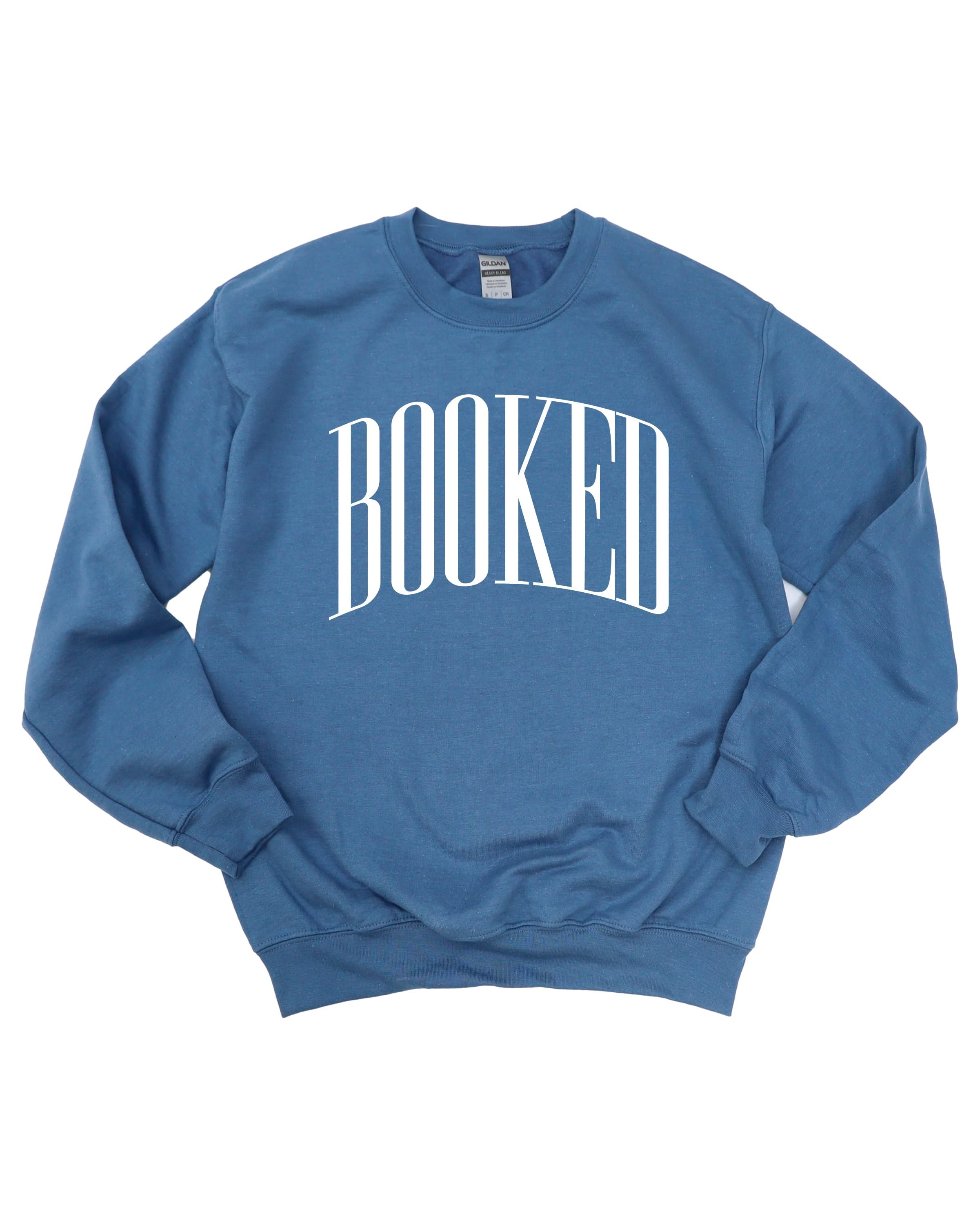 Basic fleece in indigo with 'BOOKED' graphic on chest, shown on flat lay – Little Mama Shirt Shop