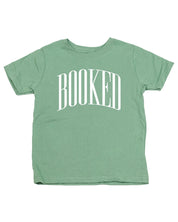 Child tee in sage with 'BOOKED' graphic on chest, shown on flat lay – Little Mama Shirt Shop