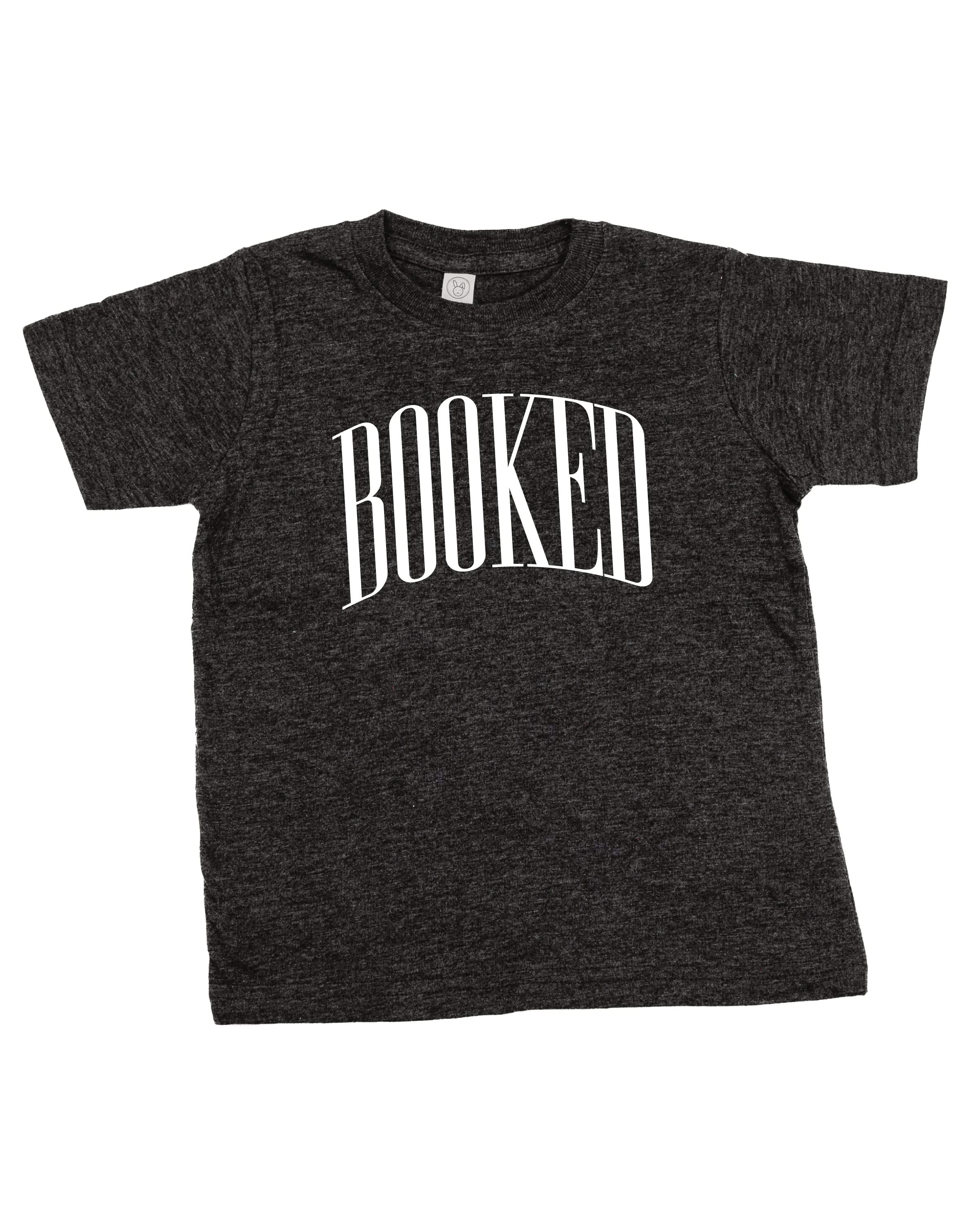 Child tee in vintage smoke with 'BOOKED' graphic on chest, shown on flat lay – Little Mama Shirt Shop