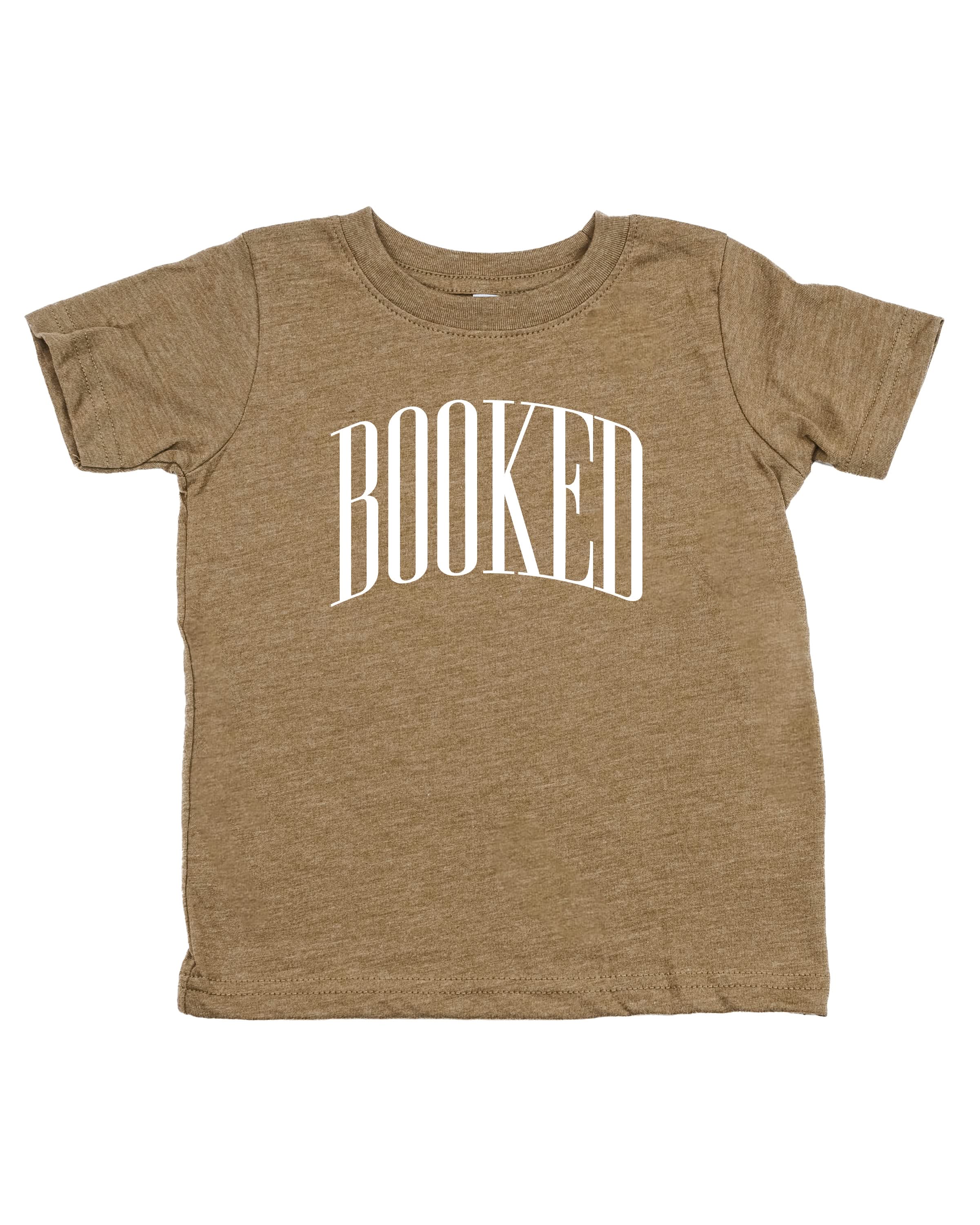 Child tee in coyote brown with 'BOOKED' graphic on chest, shown on flat lay – Little Mama Shirt Shop
