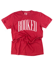 Comfort colors tee in crimson with 'BOOKED' graphic on chest, shown on flat lay – Little Mama Shirt Shop