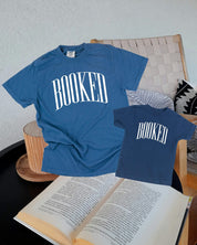 Two blue t-shirts with 'BOOKED' across the chest as a flat lay - Little Mama Shirt Shop