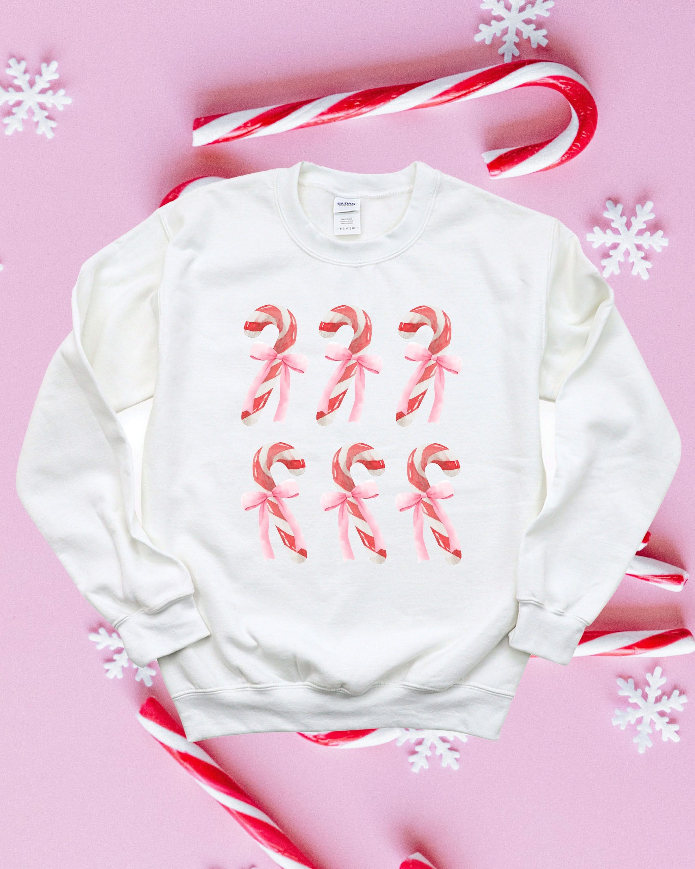 Adult Sweater in white with 6 candy canes on chest, shown on flat lay – Little Mama Shirt Shop