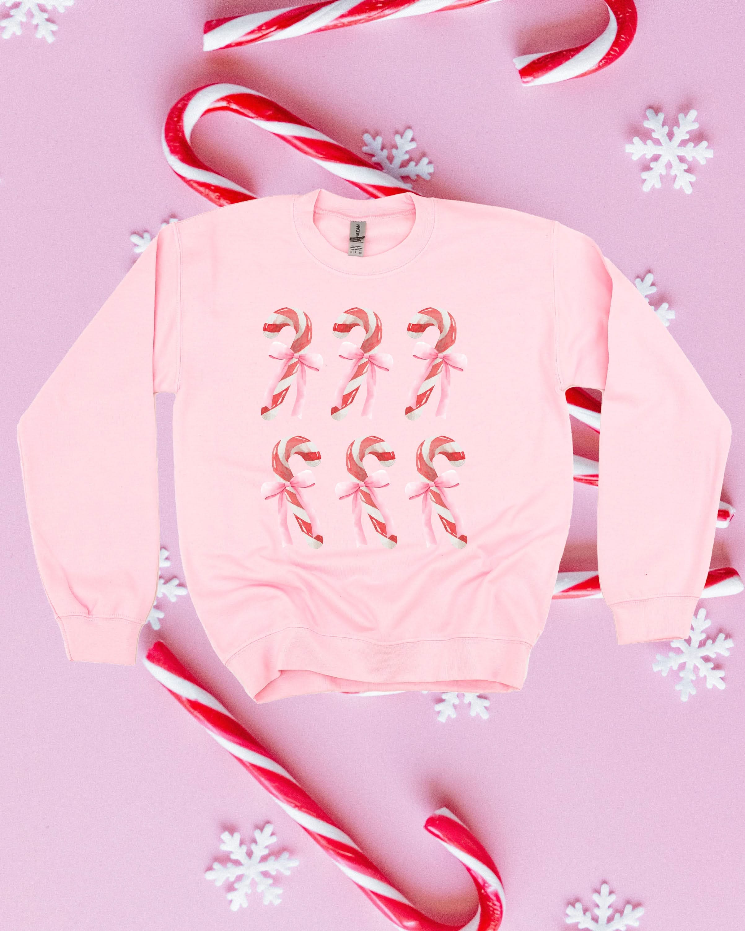 Adult Sweater in light pink with 6 candy canes on chest, shown on flat lay – Little Mama Shirt Shop