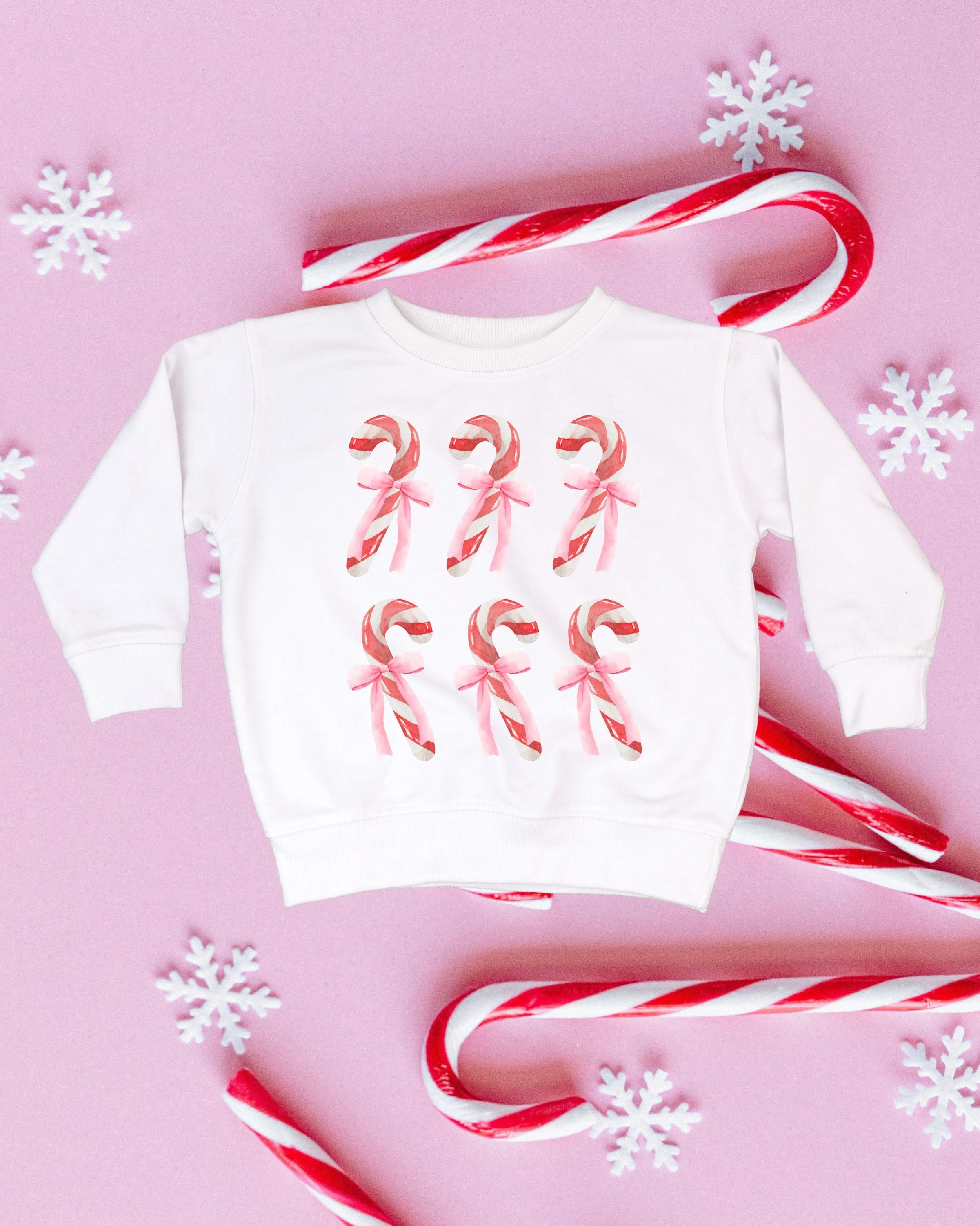 Child Sweater in white with 6 candy canes on chest, shown on flat lay – Little Mama Shirt Shop
