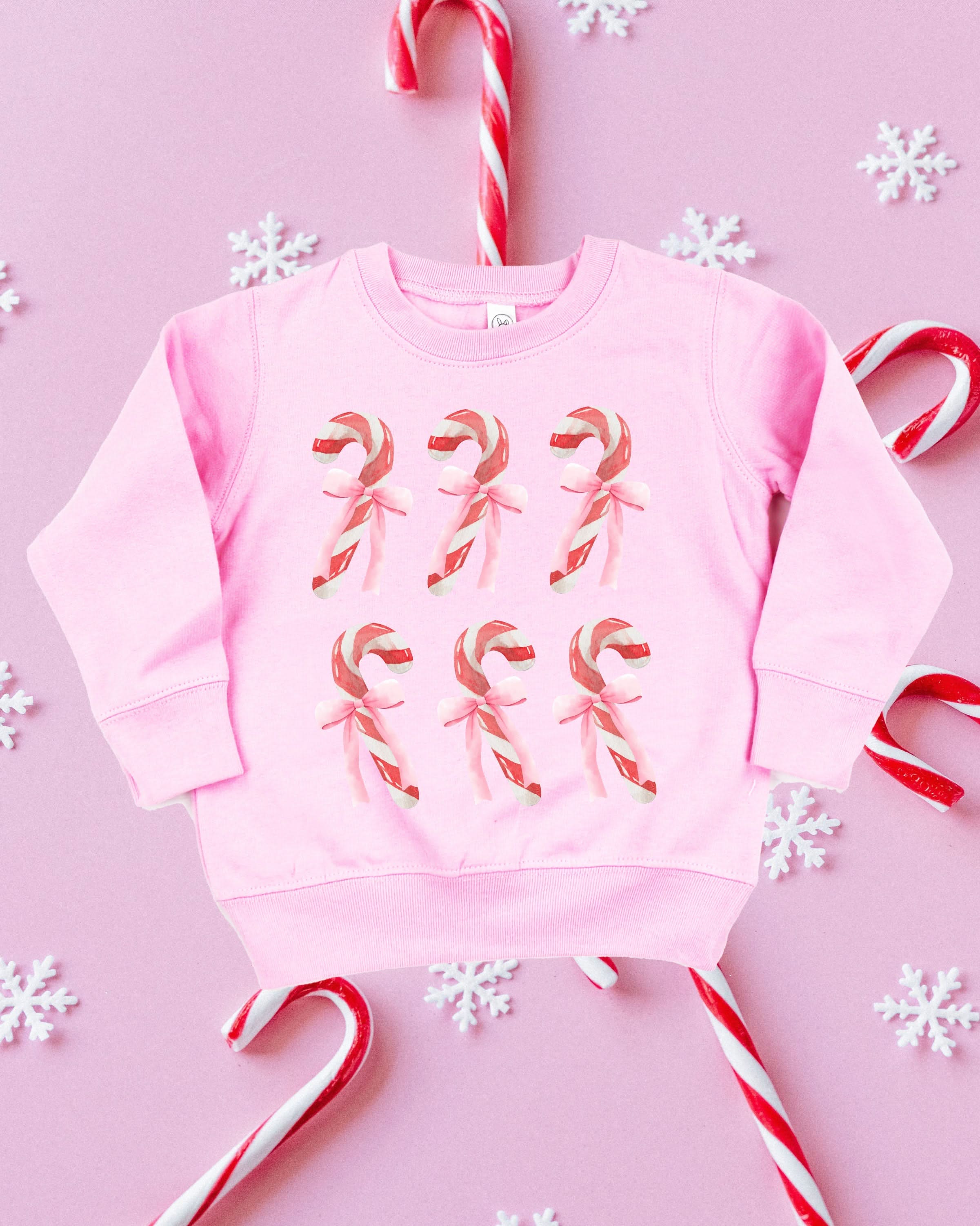 Child Sweater in pink with 6 candy canes on chest, shown on flat lay – Little Mama Shirt Shop