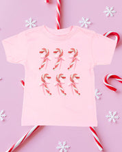 Child tee in ballerina pink with 6 candy canes on chest, shown on flat lay – Little Mama Shirt Shop