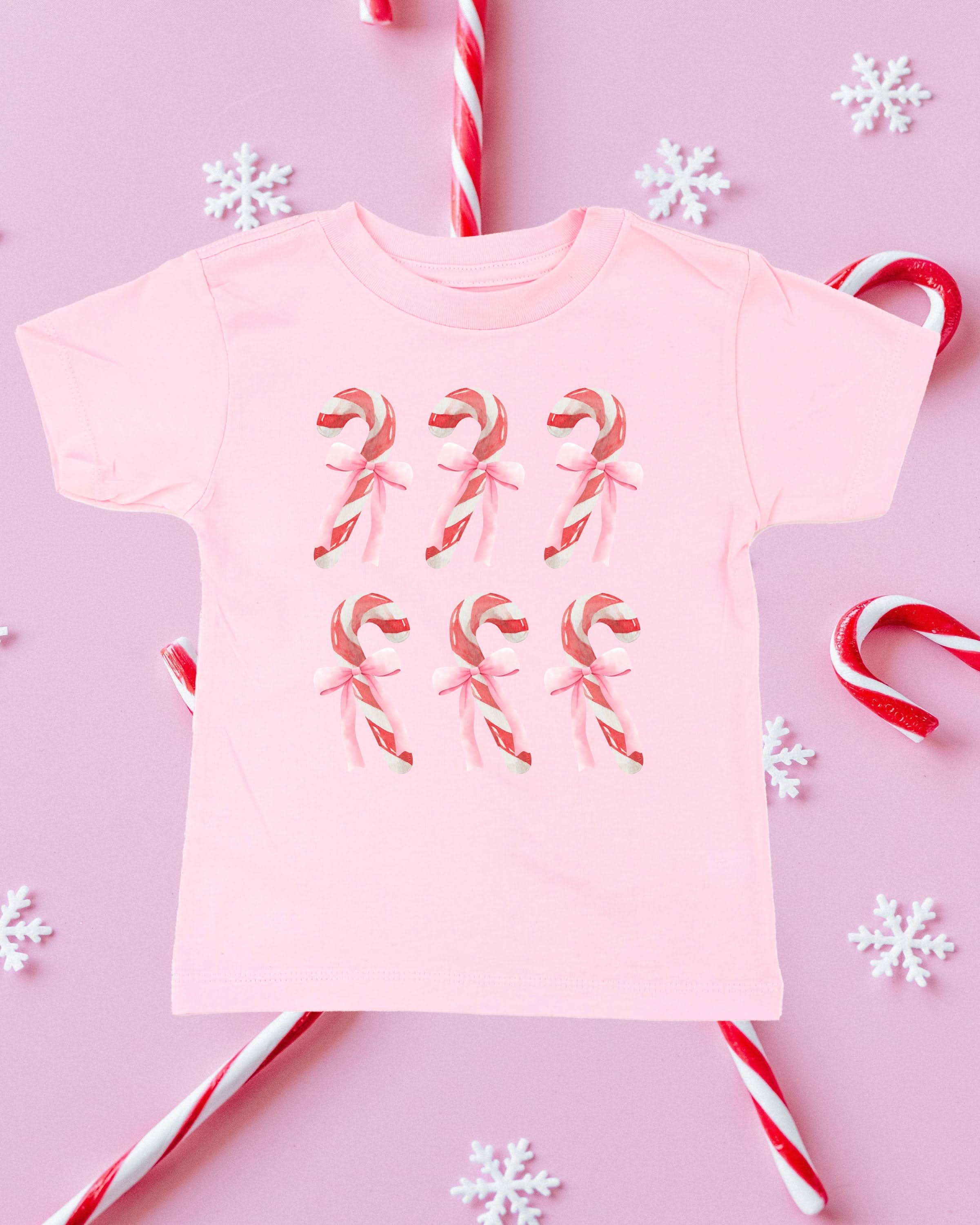 Child tee in ballerina pink with 6 candy canes on chest, shown on flat lay – Little Mama Shirt Shop
