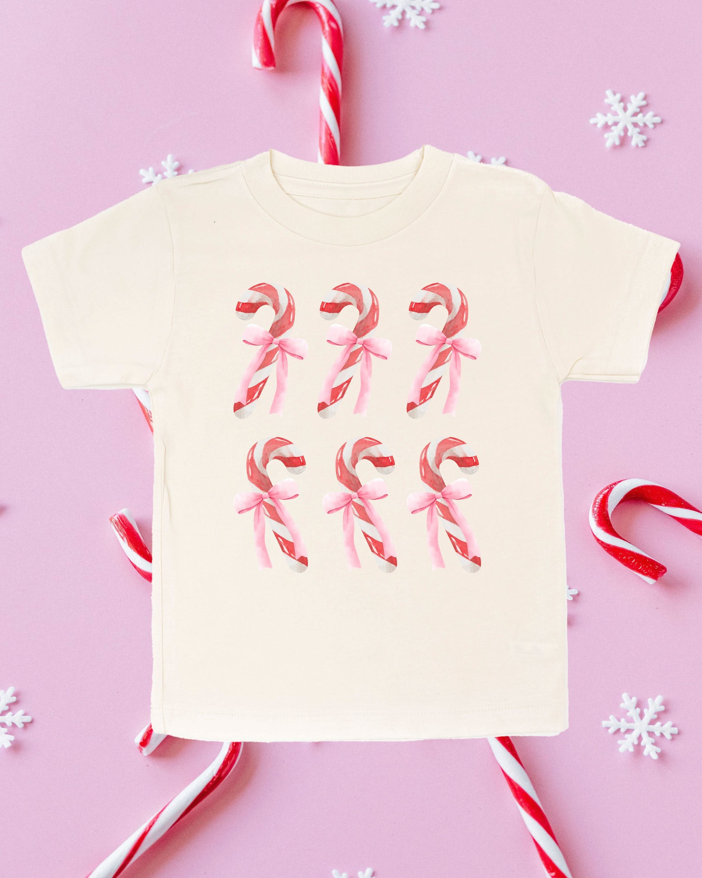 Child tee in natural with 6 candy canes on chest, shown on flat lay – Little Mama Shirt Shop