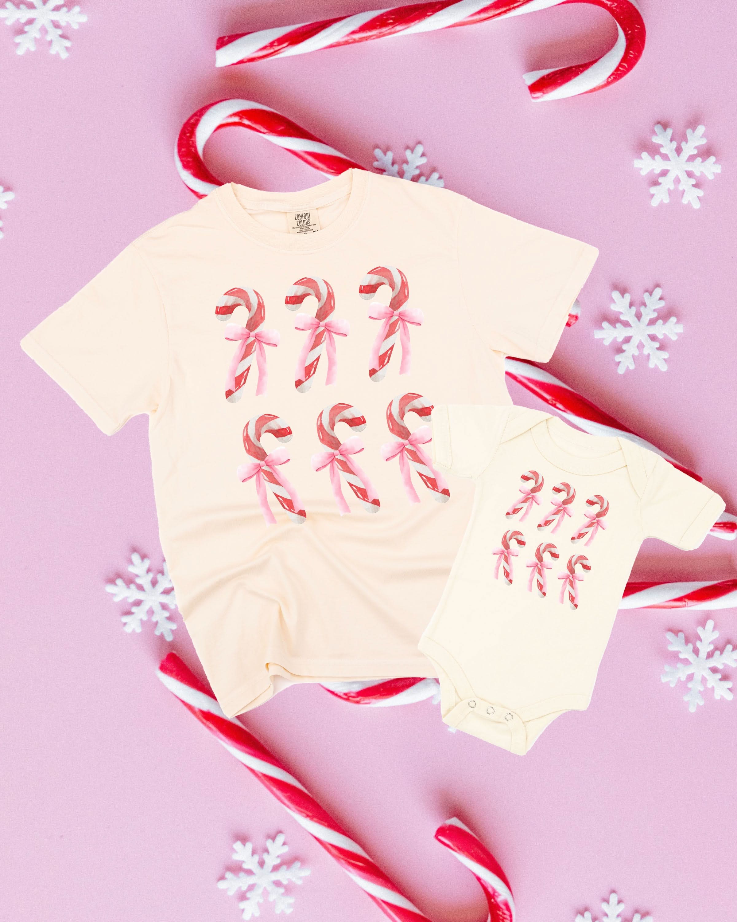 Adult and child tees in ivory and natural with 6 candy canes on chest, shown on flat lay – Little Mama Shirt Shop