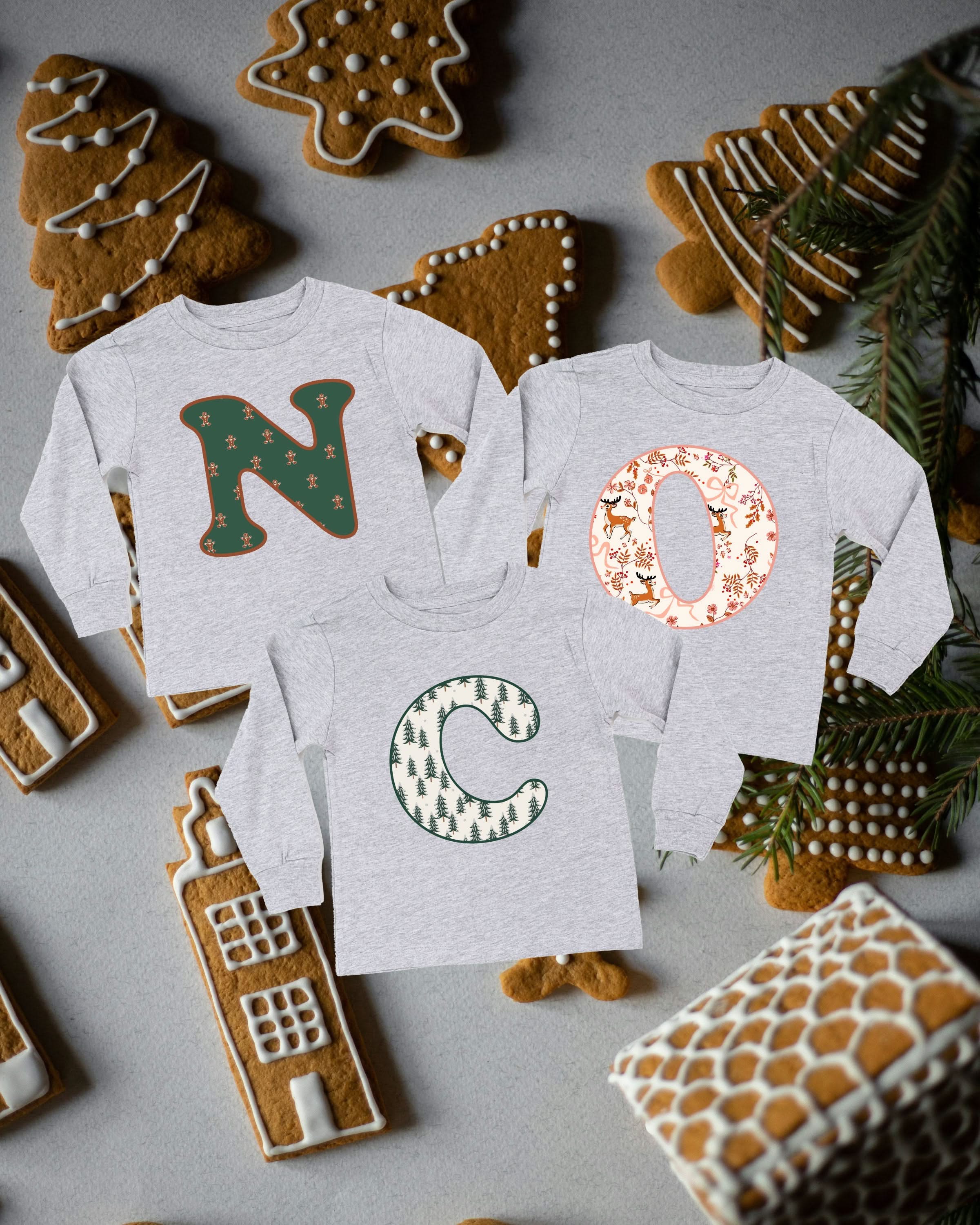 Child long sleeve in white with Christmas patterned initials on front, shown on flat lay – Little Mama Shirt Shop