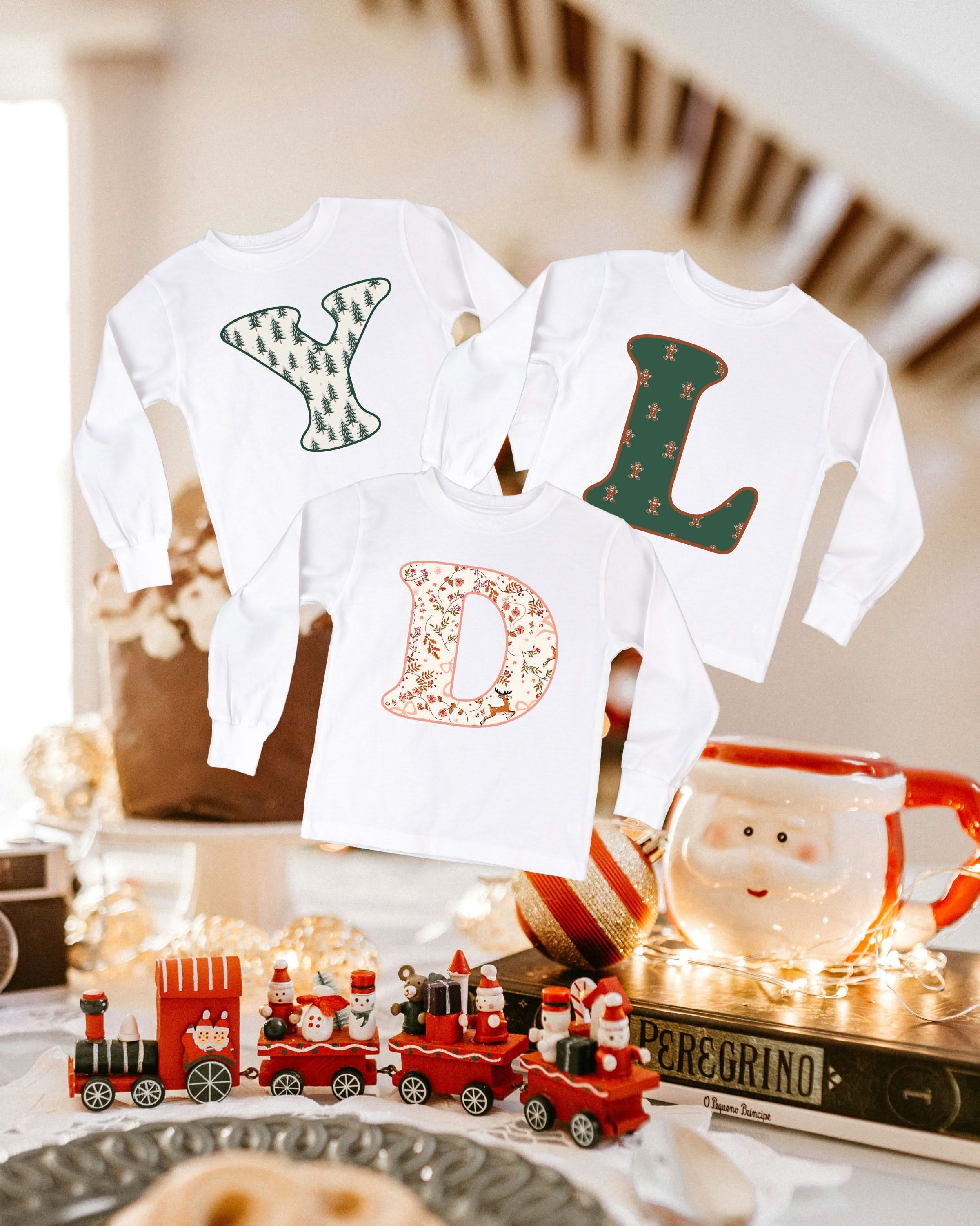Child long sleeve in white with Christmas patterned initials on front, shown on flat lay – Little Mama Shirt Shop
