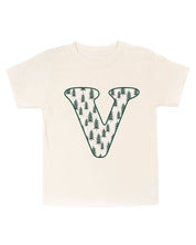Child tee in natural with Christmas pattern trees with initial V on front, shown on flat lay – Little Mama Shirt Shop