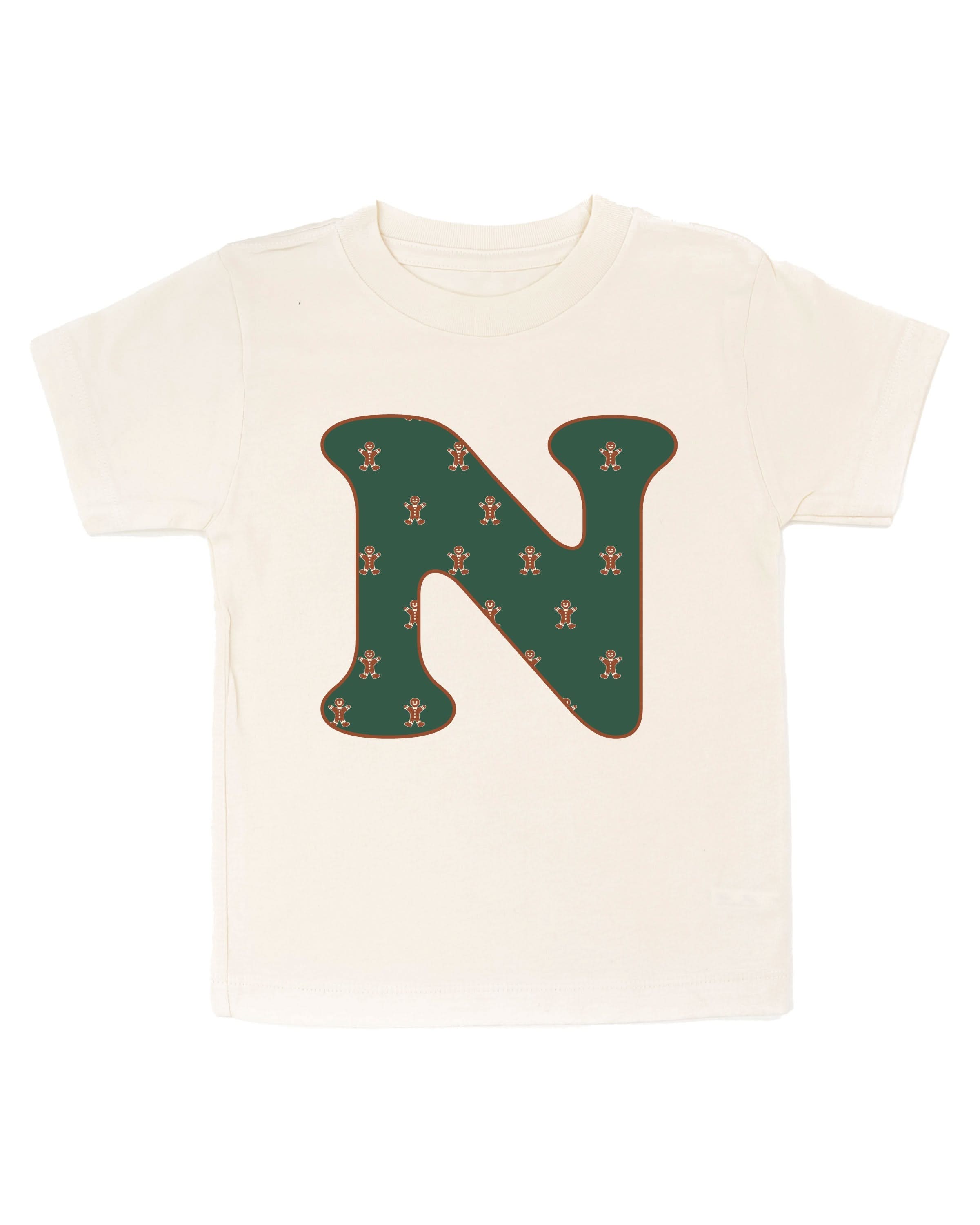 Child tee in natural with Christmas pattern gingerbread man with initial N on front, shown on flat lay – Little Mama Shirt Shop