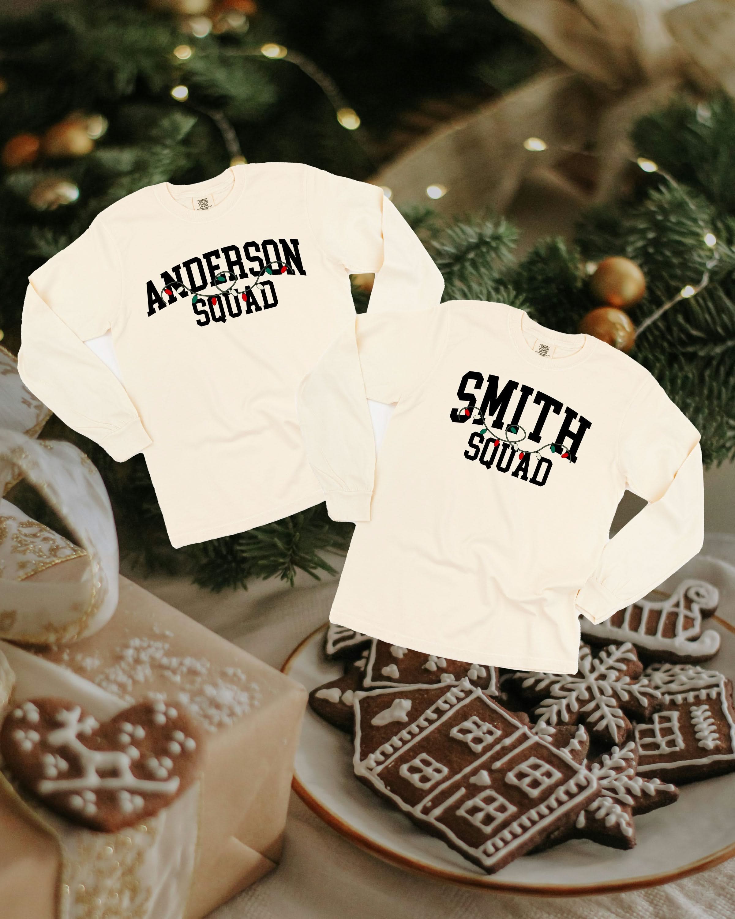 Long sleeve comfort colors tee in ivory with personalized last name printed on front with Christmas lights under, shown on flat lay – Little Mama Shirt Shop