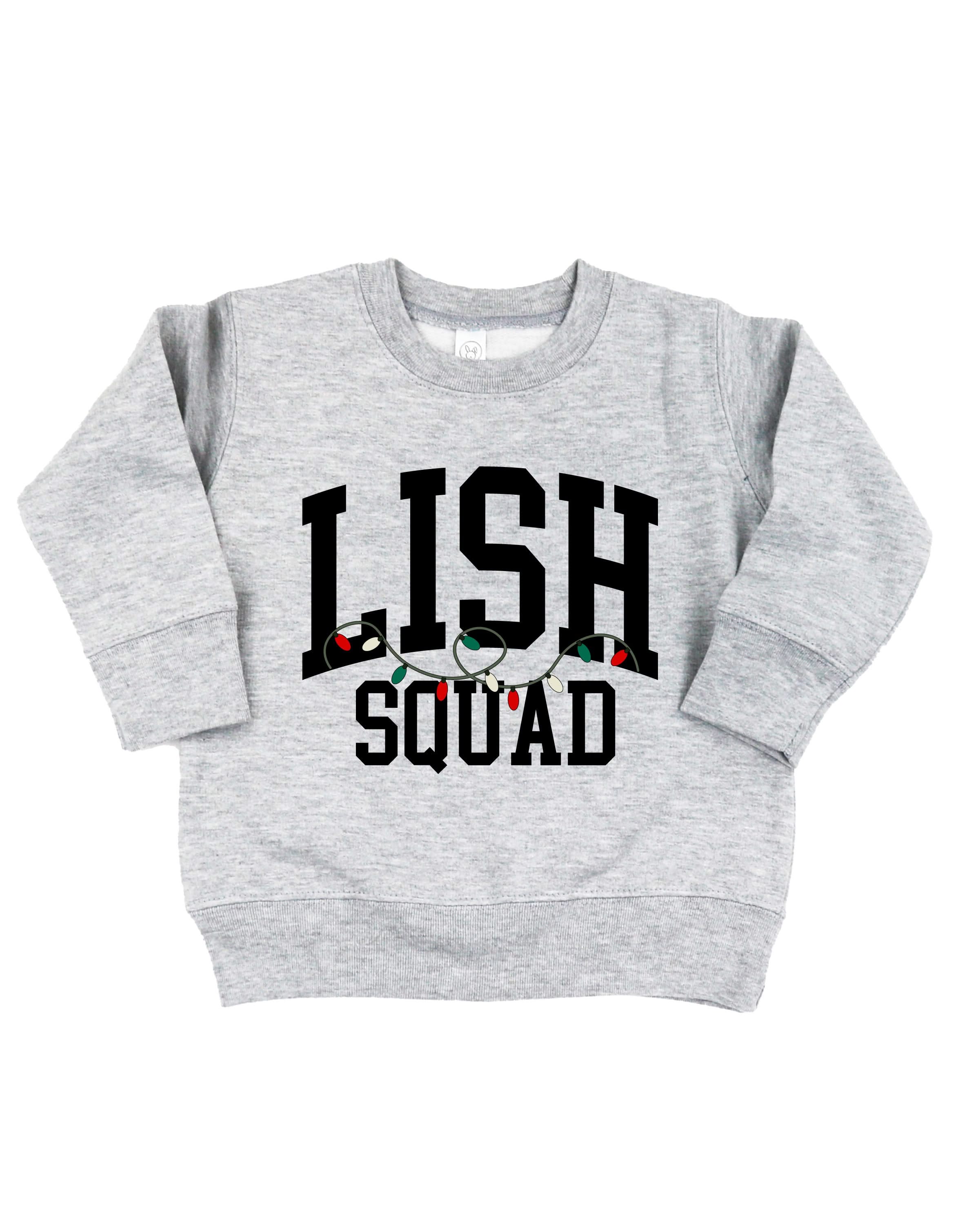 Kids basic fleece in gray with personalized last name printed on front with Christmas lights under, shown on flat lay – Little Mama Shirt Shop