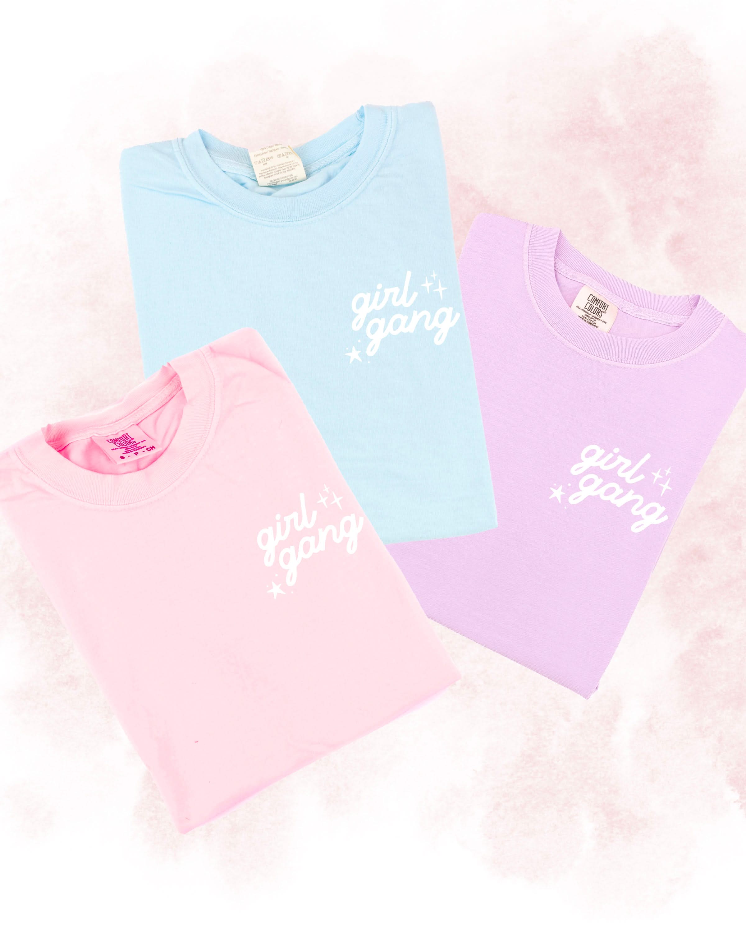 Adult tees in blossom, chambray, and orchid with "girl gang" design on front chest, shown on flat lay - Little Mama Shirt Shop