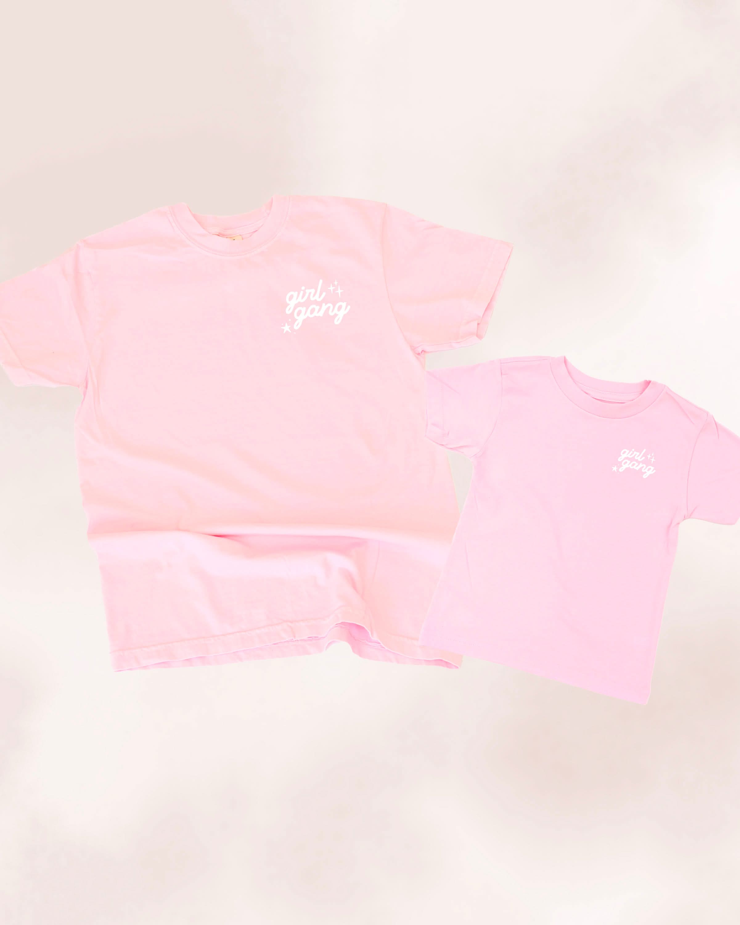 Adult and child tees in blossom and ballerina pink with "girl gang" design on front chest, shown on flat lay - Little Mama Shirt Shop