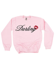 Adult pink sweater with "Darling" script and lipstick kiss design, shown on flat lay  – Little Mama Shirt Shop