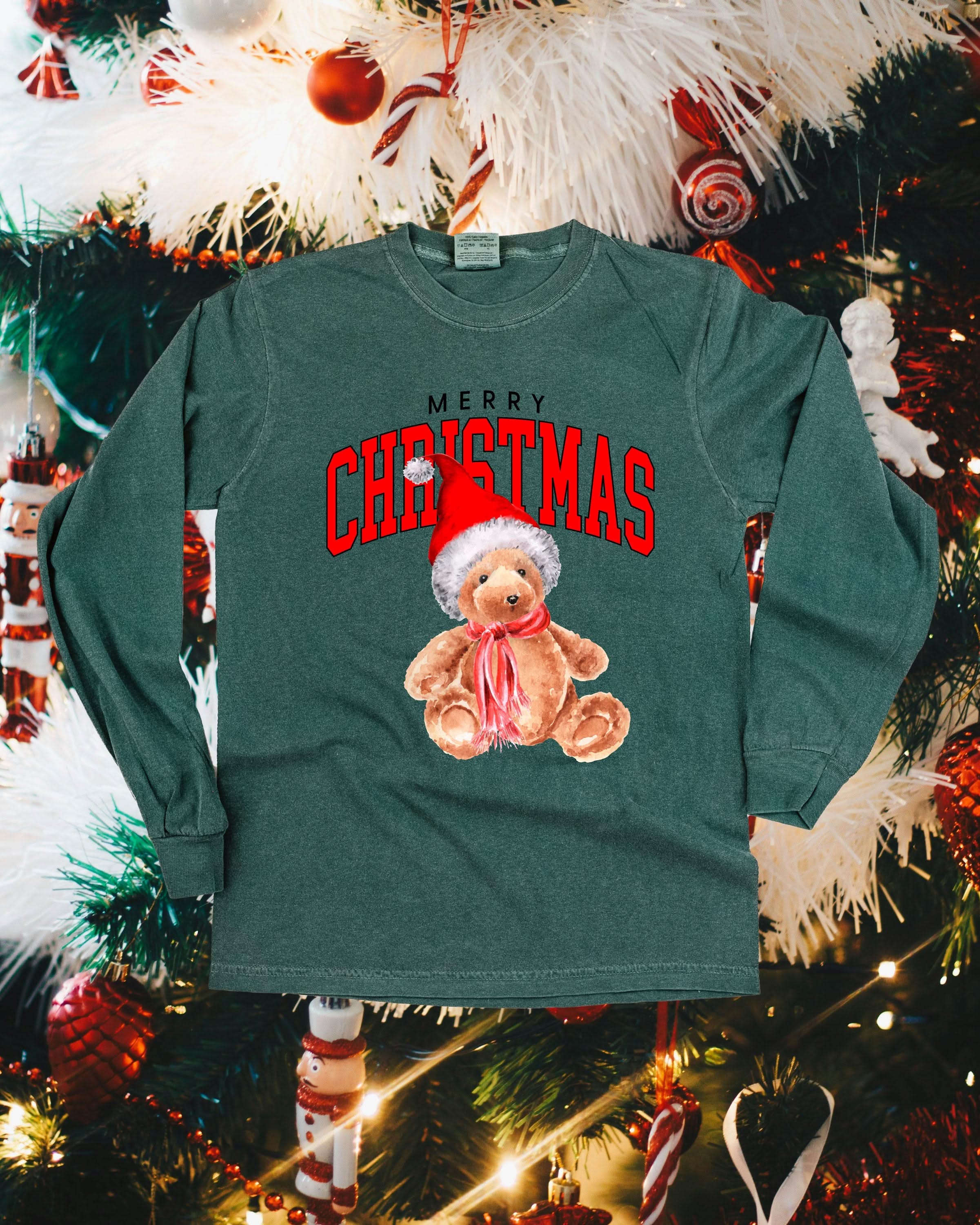 Adult long sleeve comfort colors tee in blue spruce with merry Christmas teddy graphic, shown on flat lay – Little Mama Shirt Shop