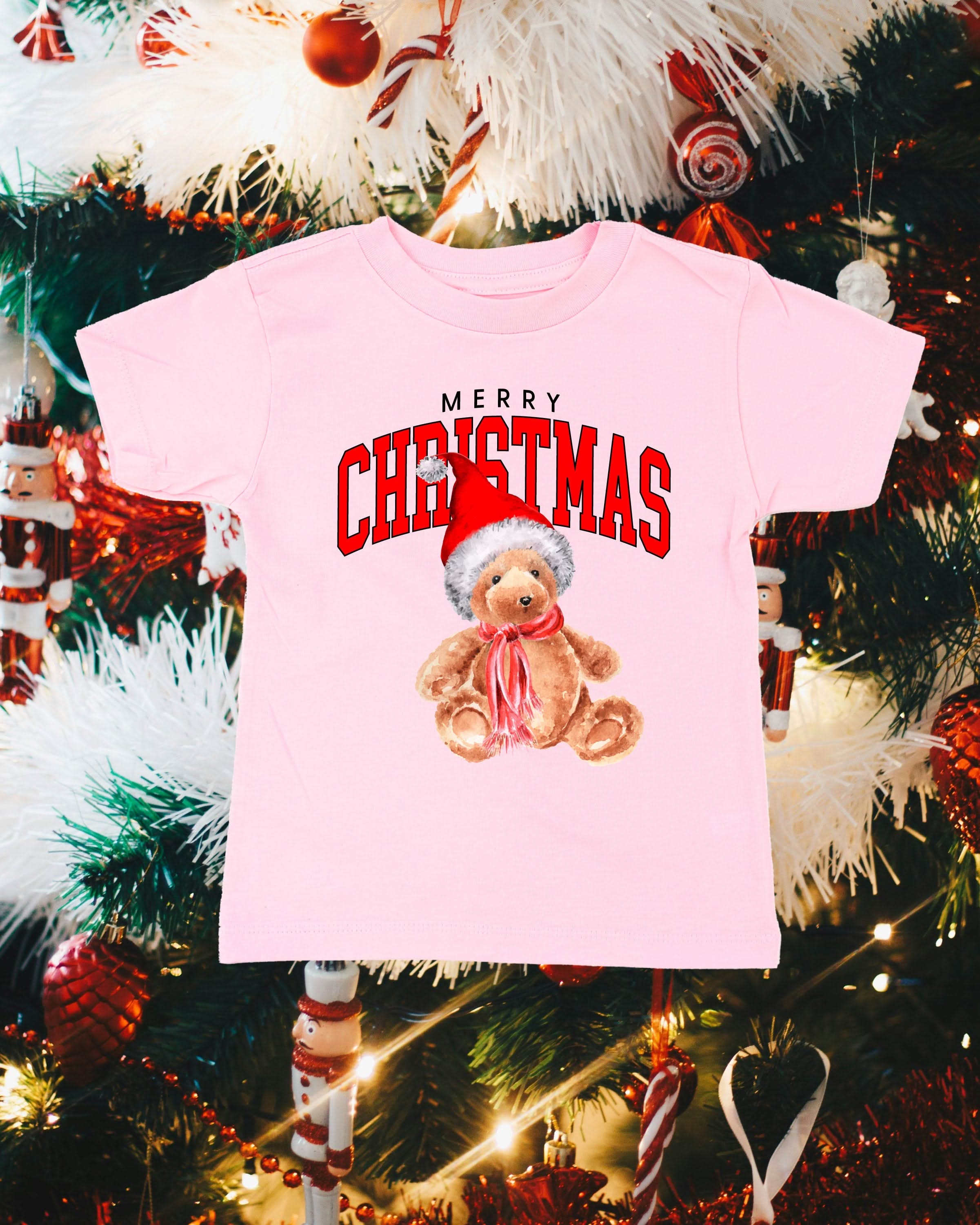 Child tee in ballerina pink with merry Christmas teddy graphic, shown on flat lay – Little Mama Shirt Shop