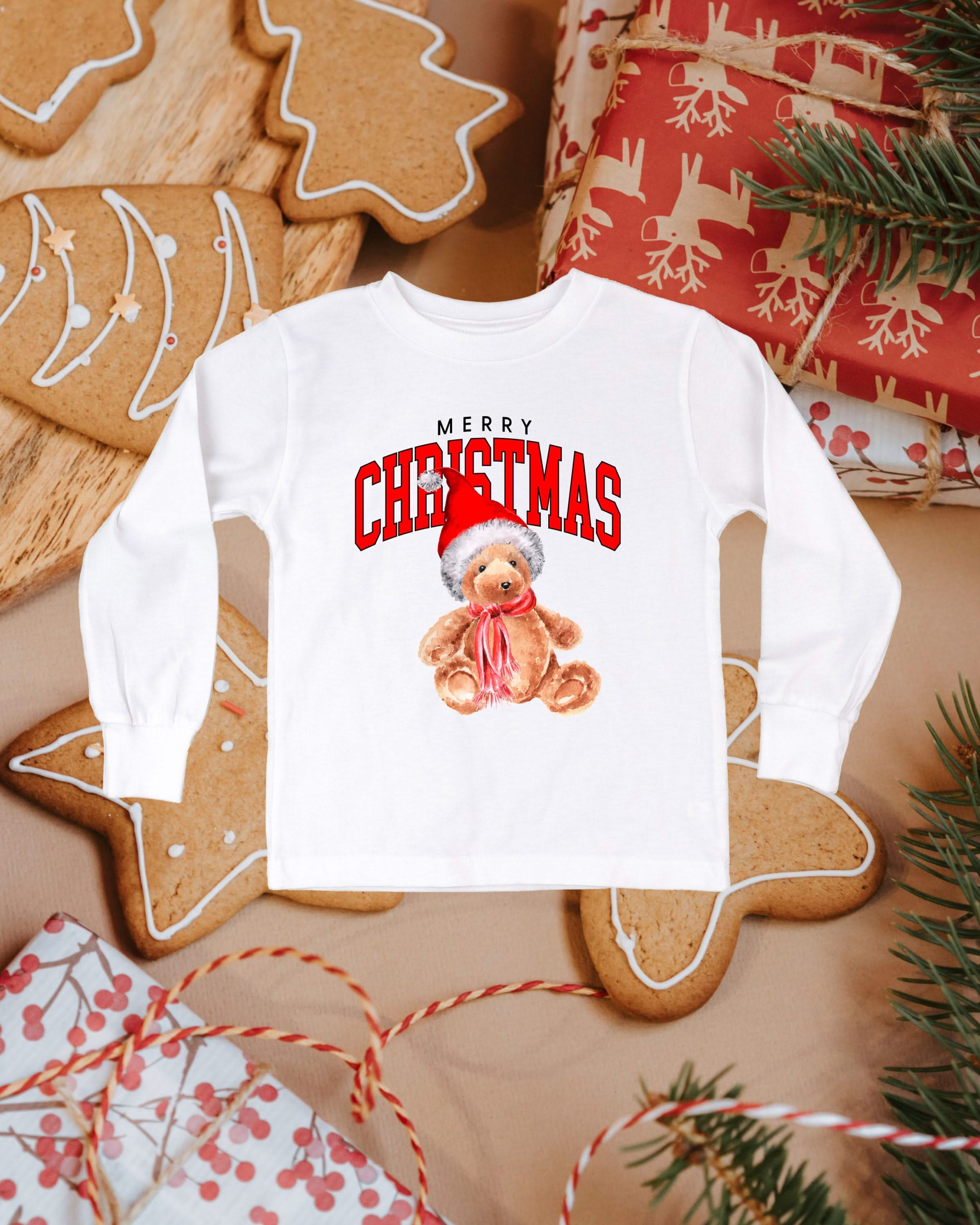 Child long sleeve in white with merry Christmas teddy graphic, shown on flat lay – Little Mama Shirt Shop