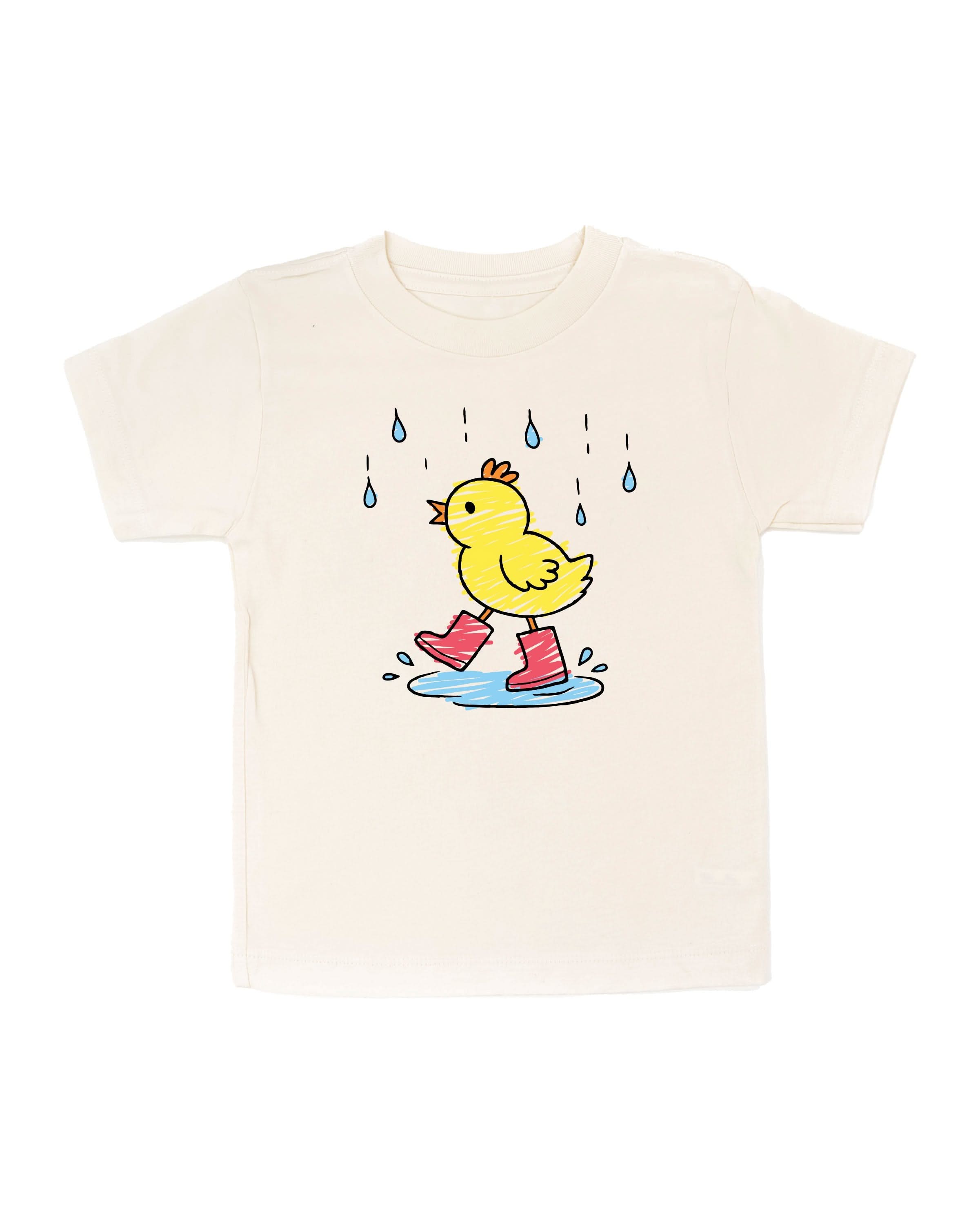 Child tee in natural with little yellow duck with red rain boots in the rain drawing on front, seen on flat lay - Little Mama Shirt Shop