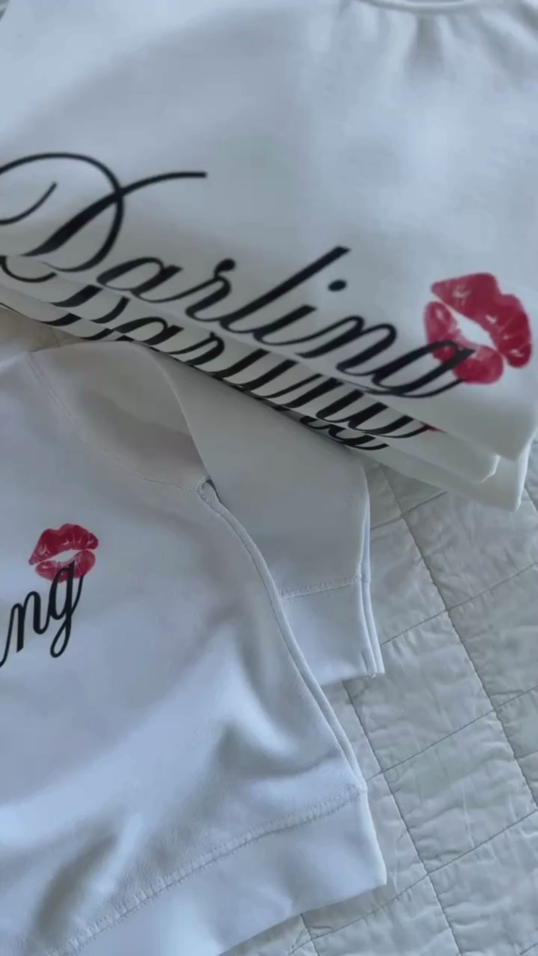Video of child white sweater with "Darling" script and lipstick kiss design, shown on flat lay  – Little Mama Shirt Shop