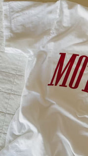 Video of white adult comfort colors tee with red 'mother' puff print across the front, seen on flat lay - Little Mama Shirt Shop