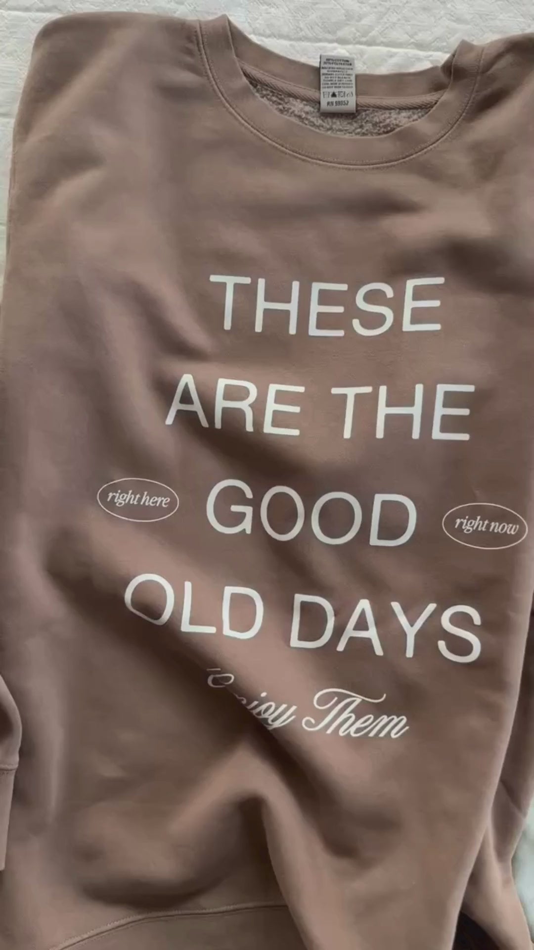 Video of adult pigment crewneck in brown, sage, and black with 'these are the good old days'  printed on the front, seen on flat lay - Little Mama Shirt Shop