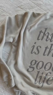 Video of adult fleece in cream with 'this is the good life' printed on the back, seen on flat lay - Little Mama Shirt Shop