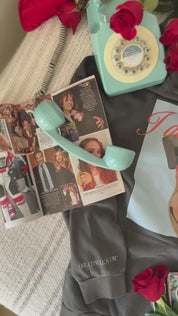 Video of adult black hoodie with "I Don't Care" retro cassette on front and "JK I Actually Do" text on sleeve, shown on model  – Little Mama Shirt Shop