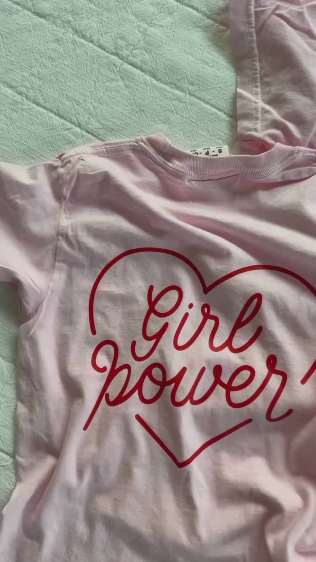 Video of adult and youth blossom comfort colors tee with girl power script in heart design on pocket and back, seen on flat lay - Little Mama Shirt Shop