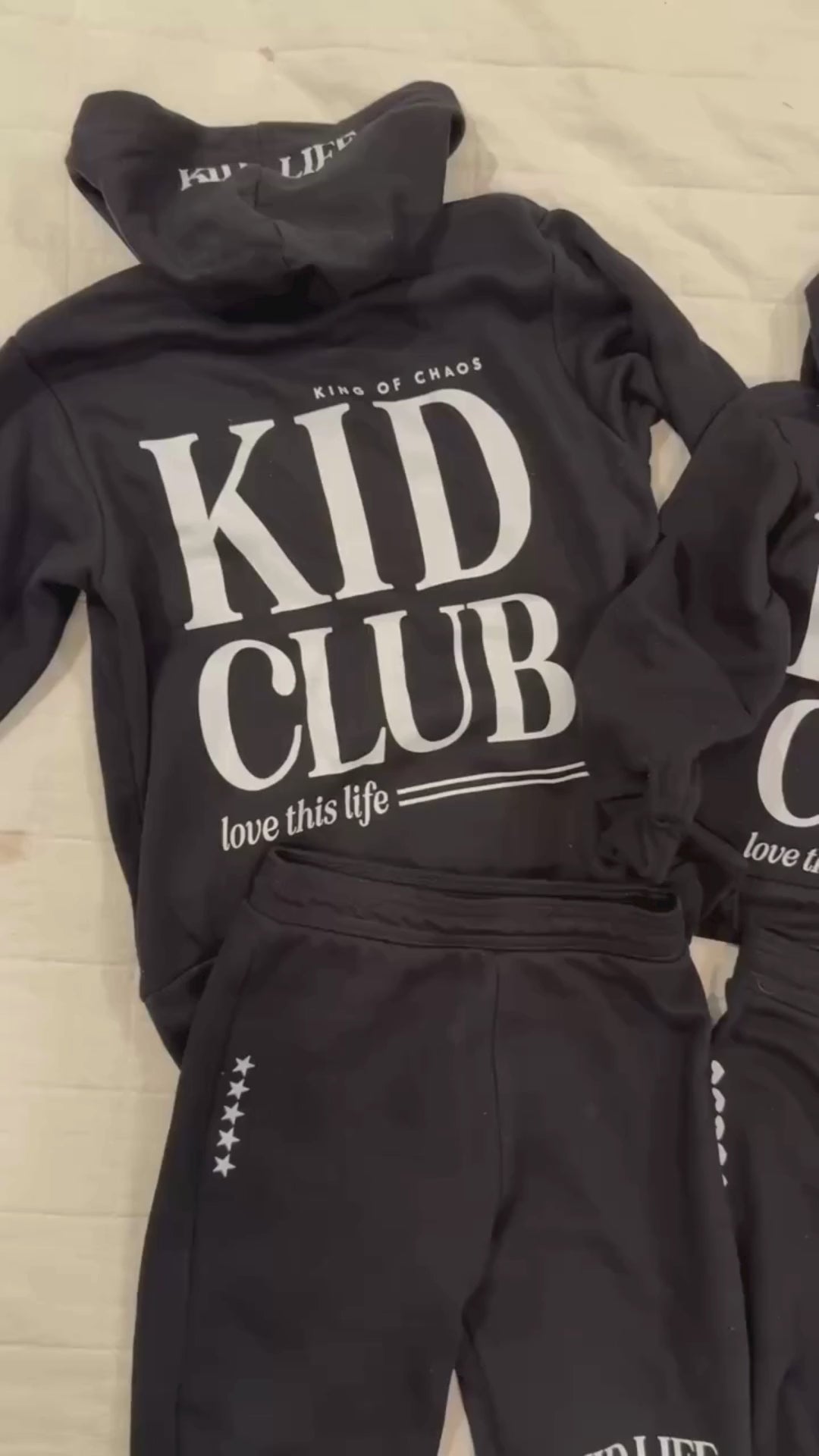 Video of hoodies in black with white 'Kid Club' graphic seen on flat lay - Little Mama Shirt Shop